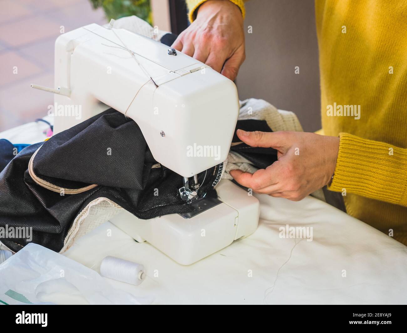 Female hands  Using Sewing electric Machine at home Stock Photo