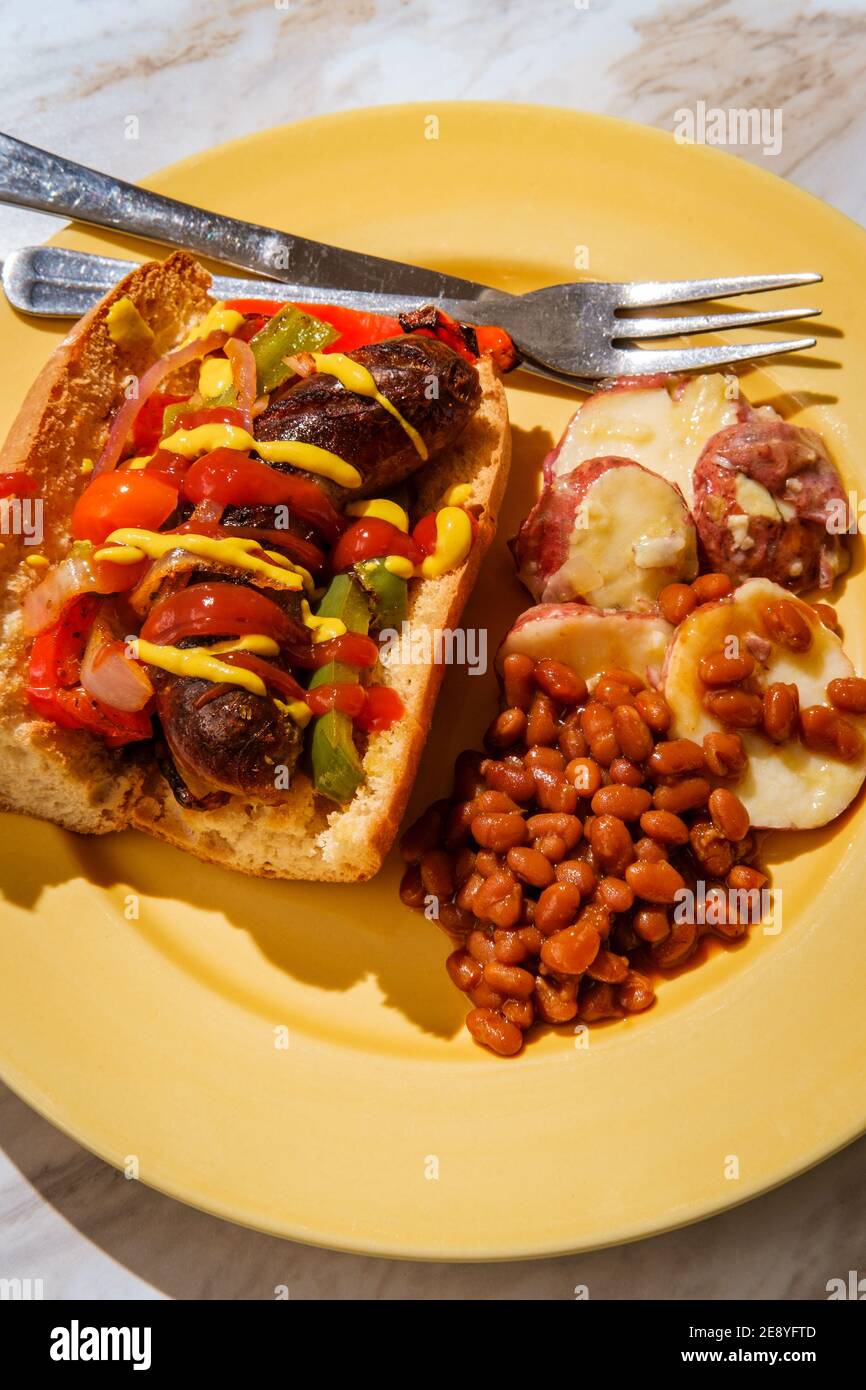 Sausage onions and peppers hoagie sandwich with side of baked beans and