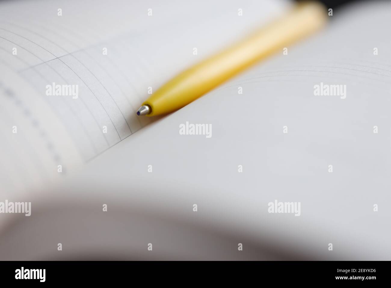 Yellow ballpoint pen lying on notebook closeup Stock Photo