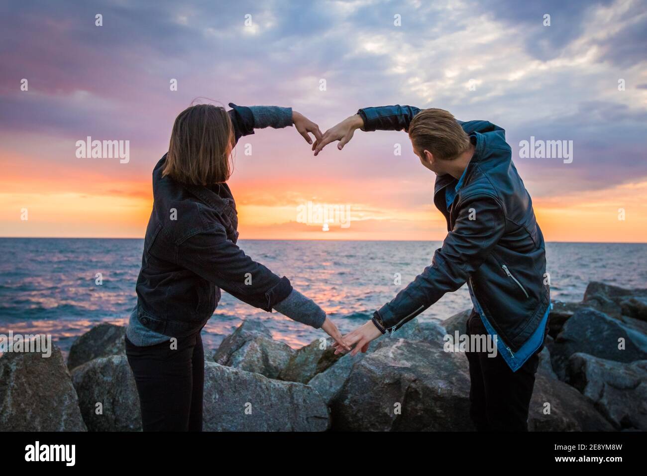 Mesmerizing shot of a loving couple making a heart shape with their ...