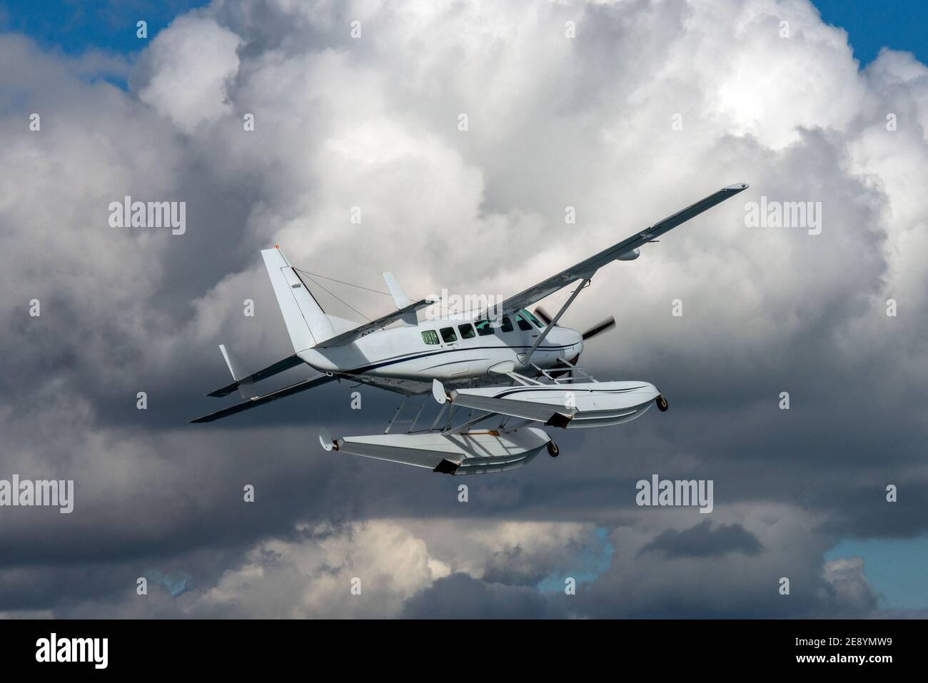 An air to air portrait of a Cessna 208 Grand Caravan float plane approaching turbulent clouds. Stock Photo