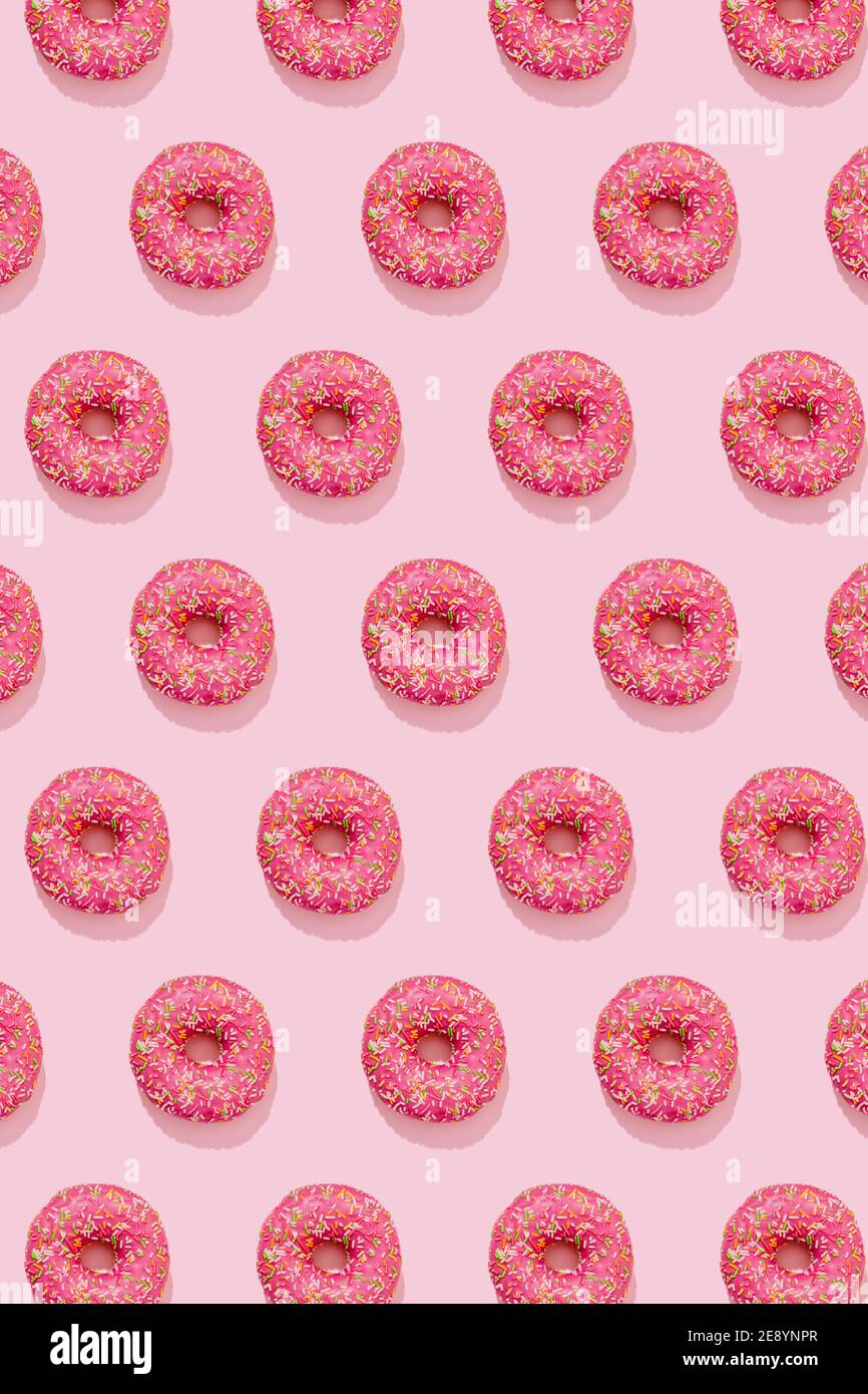 Donut pattern in pink glaze with colorful sprinkles on pink background  Stock Photo - Alamy