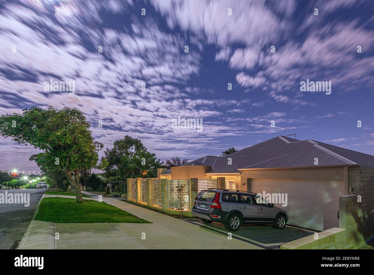 A night time exposure by moonlight of a modern Australian suburban street, with a Volvo car in a driveway. Stock Photo