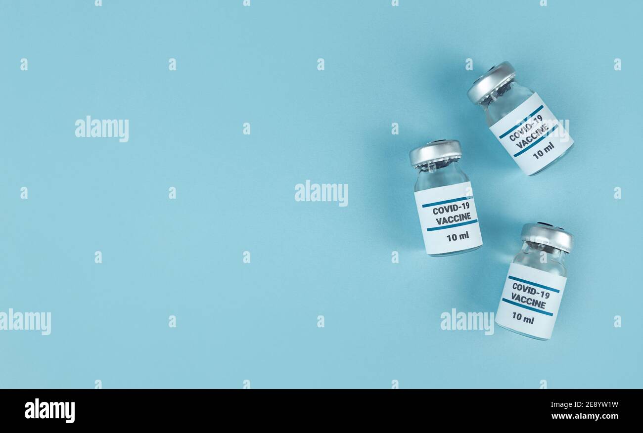 Medicine bottles with covid 19 vaccine on blue background with copy ...