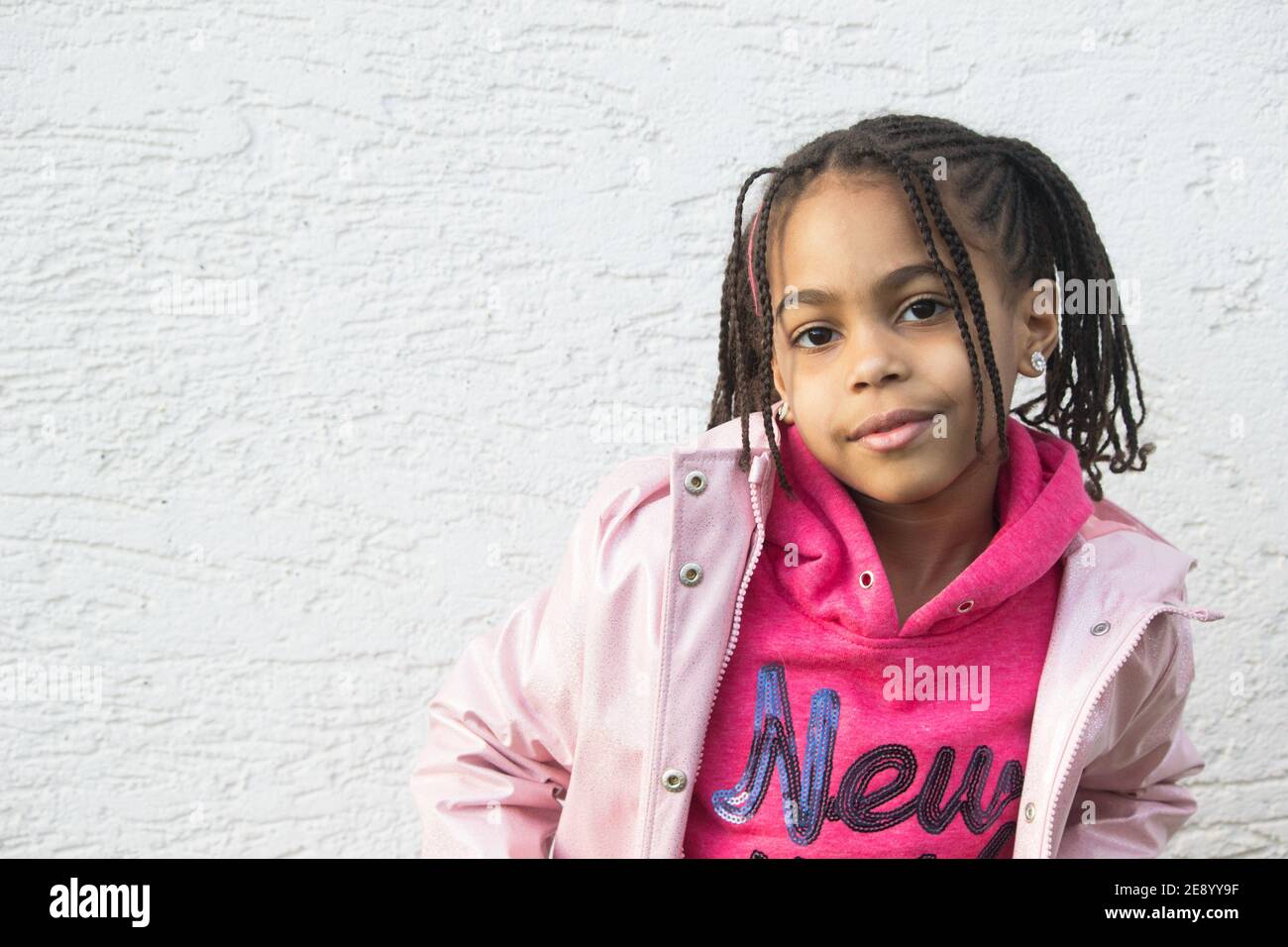 Outdoors portrait of cute happy toddler mixed race girl wearing a pink  coat,warm protective boots and leggings Stock Photo - Alamy