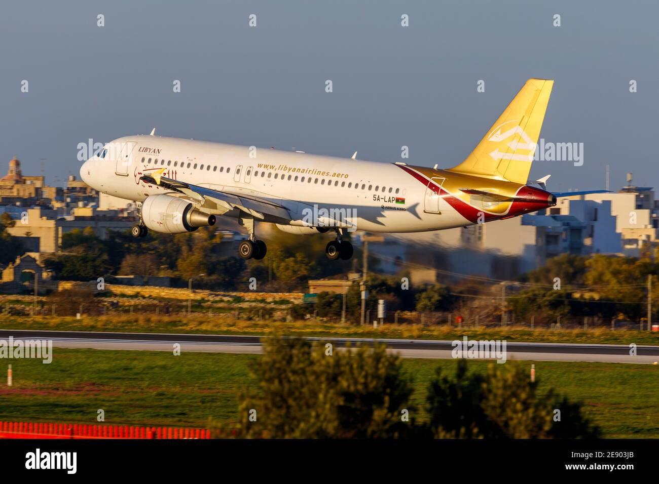 Libyan Airlines Airbus A320-214 (Reg: 5A-LAP) arriving in the late evening from Tripoli, Libya. Stock Photo