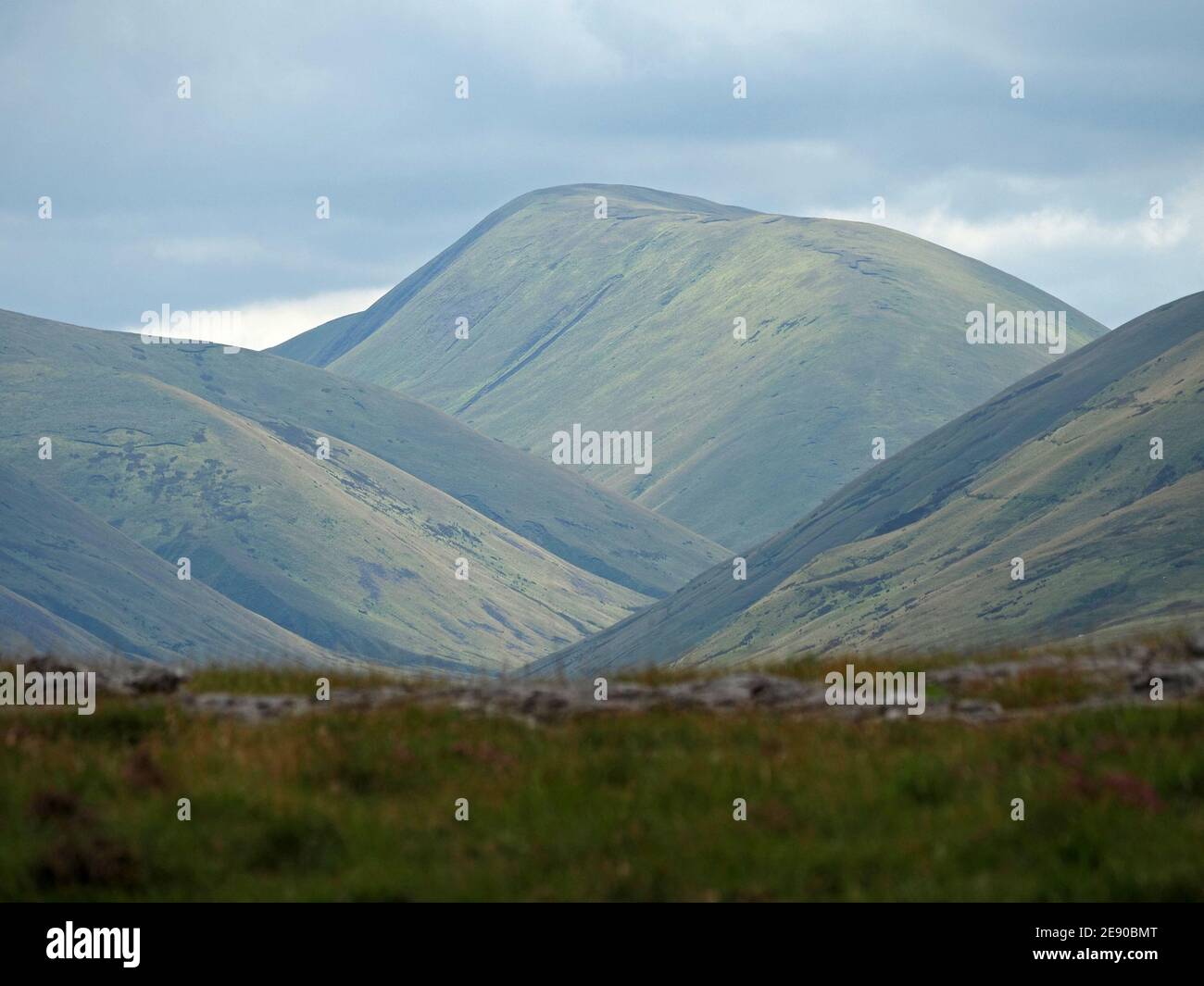 Summer dappled light on Green Bell, a peak in the Howgill Hills, seen from the Eden Valley in Cumbria, England, UK Stock Photo