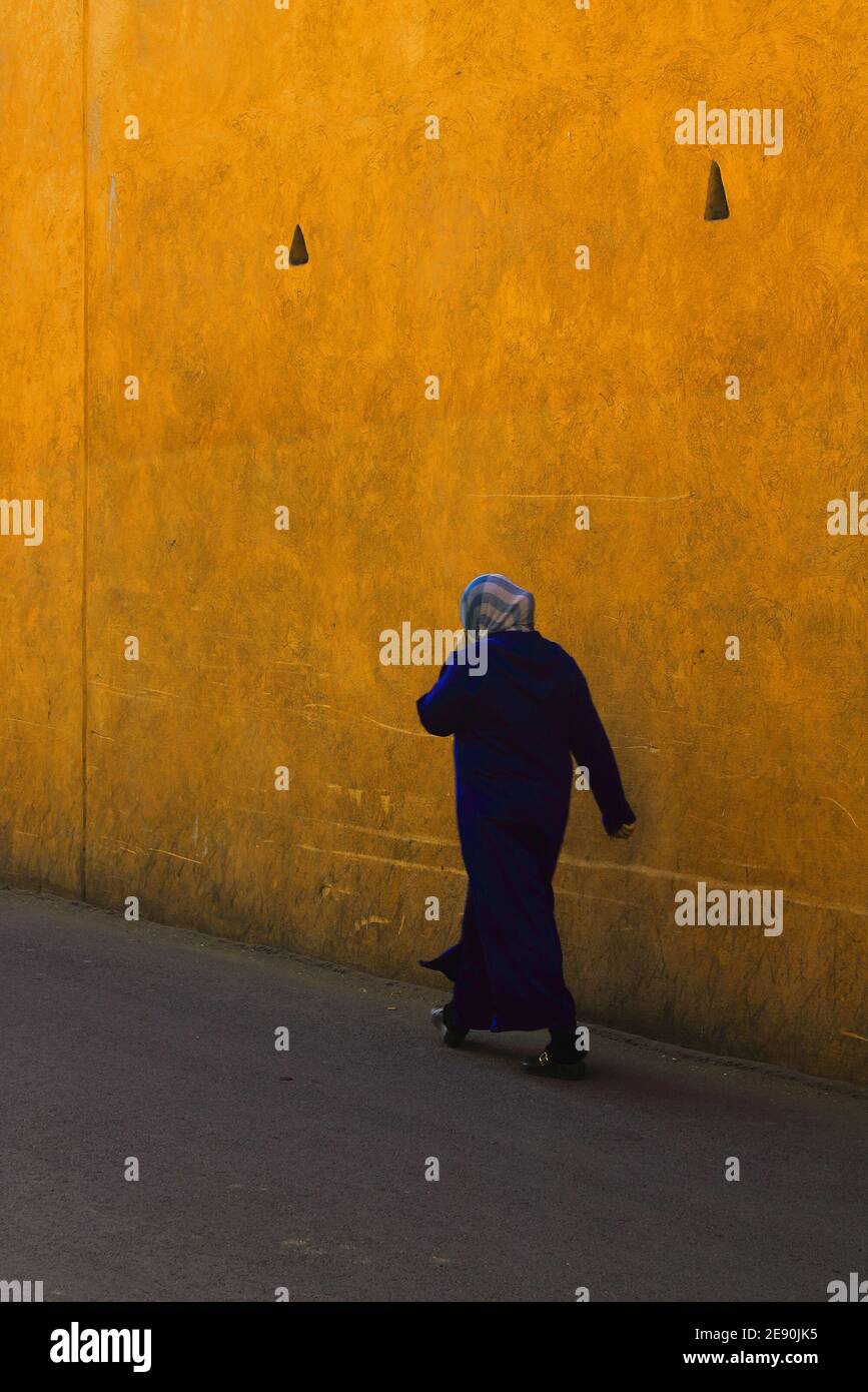 Arab woman in hijab walking alone on street Stock Photo
