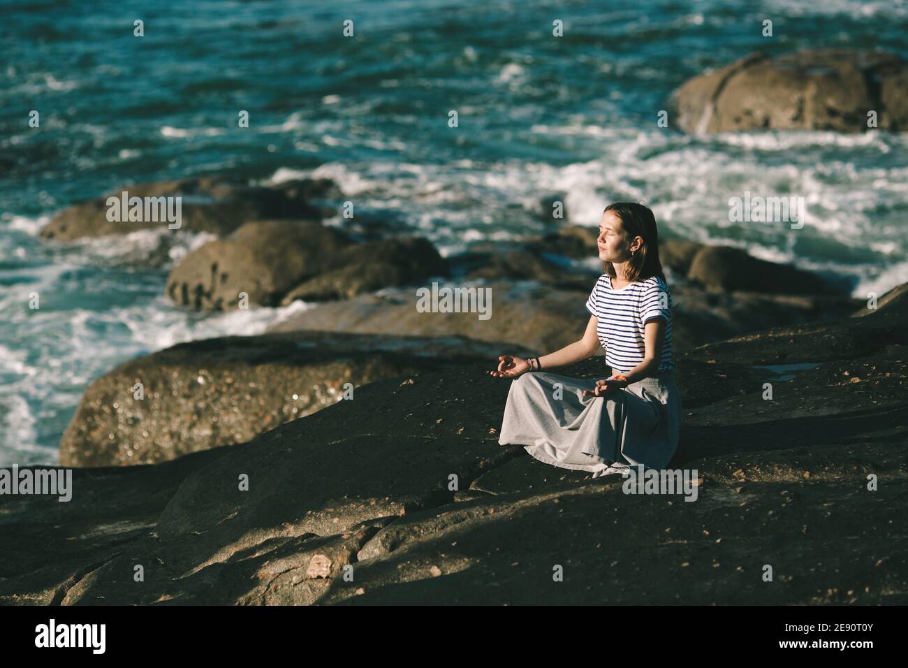 A beautiful young yoga woman meditates in the lotus position, sitting