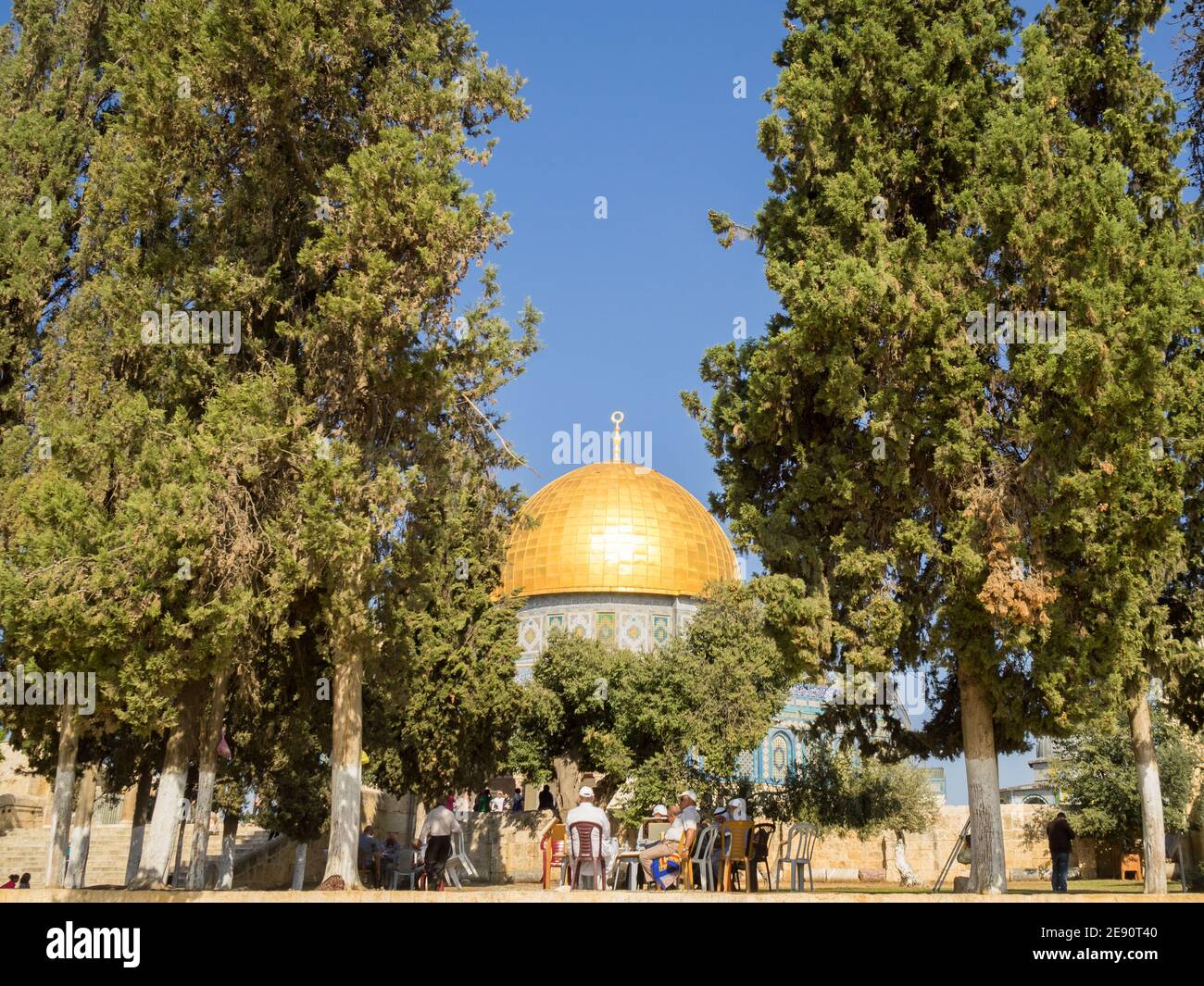 Muslim men talking under the trees by the Dome of the Rock in Temple Mount Stock Photo