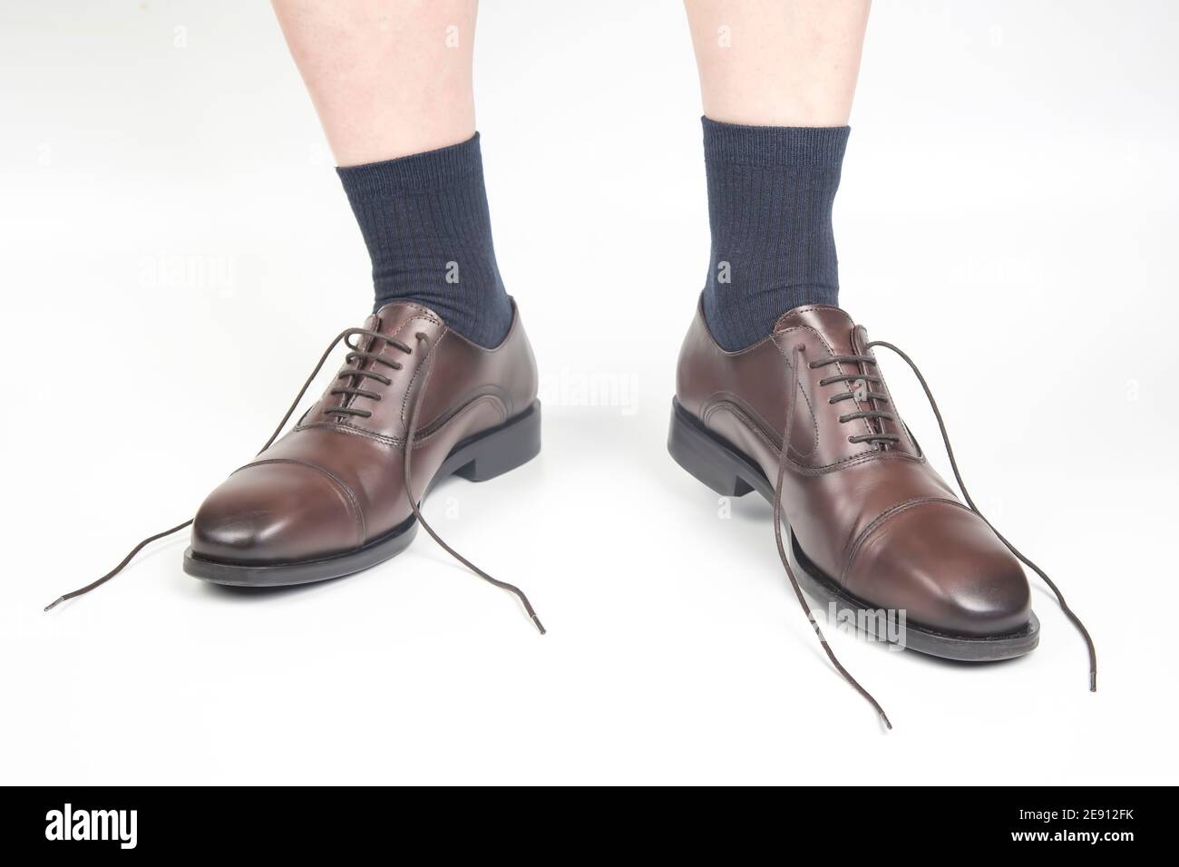 Male legs in socks and brown classic shoes on a white background Stock