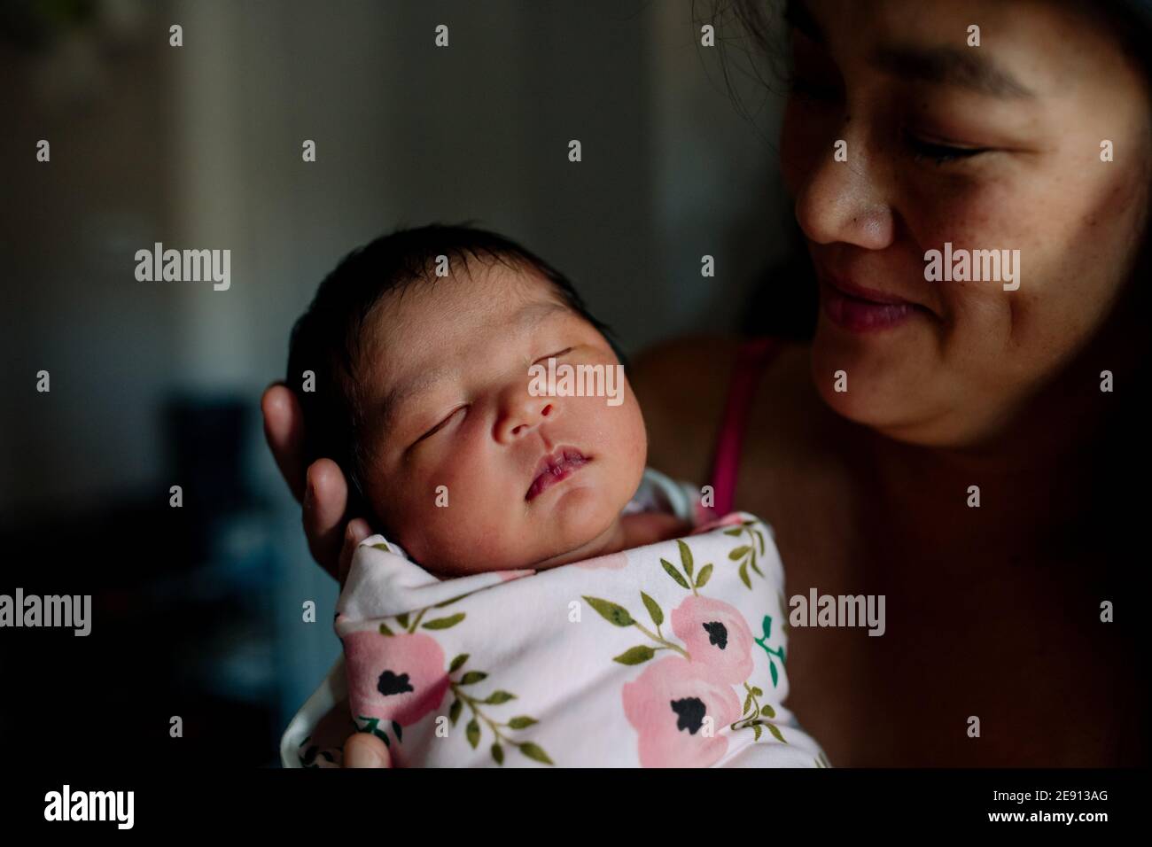 Loving asian mom admires newborn baby Stock Photo