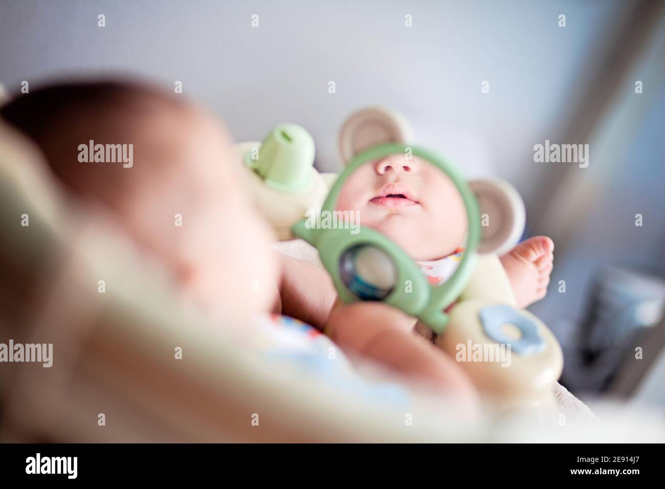 4 month old baby looking at himself in the mirror. Stock Photo