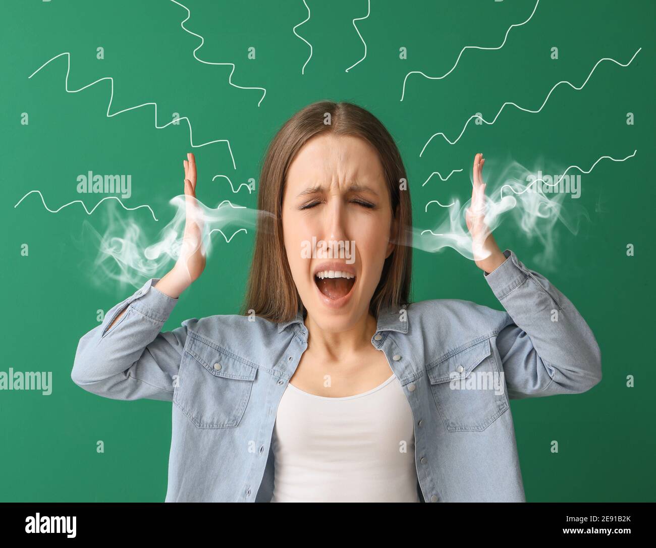 Angry young woman with steam coming out of ears on color background Stock Photo