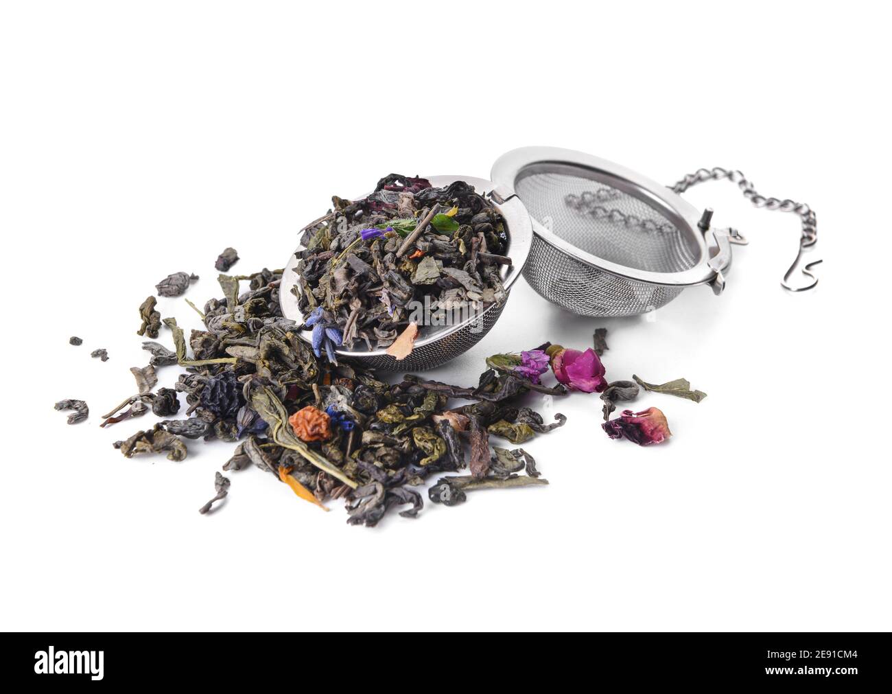 Tea strainer with dry leaves and flowers on white background Stock