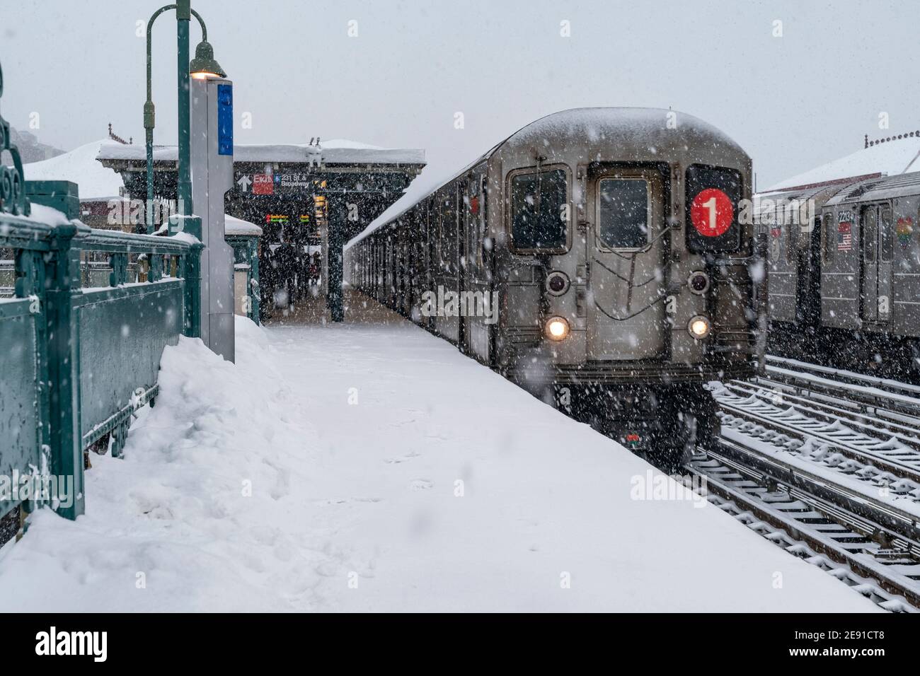 New York, NY - February 1, 2021: View of subway train on elevated above ground station covered with snow as major storm cover New York City with more than a foot expected on the ground Stock Photo