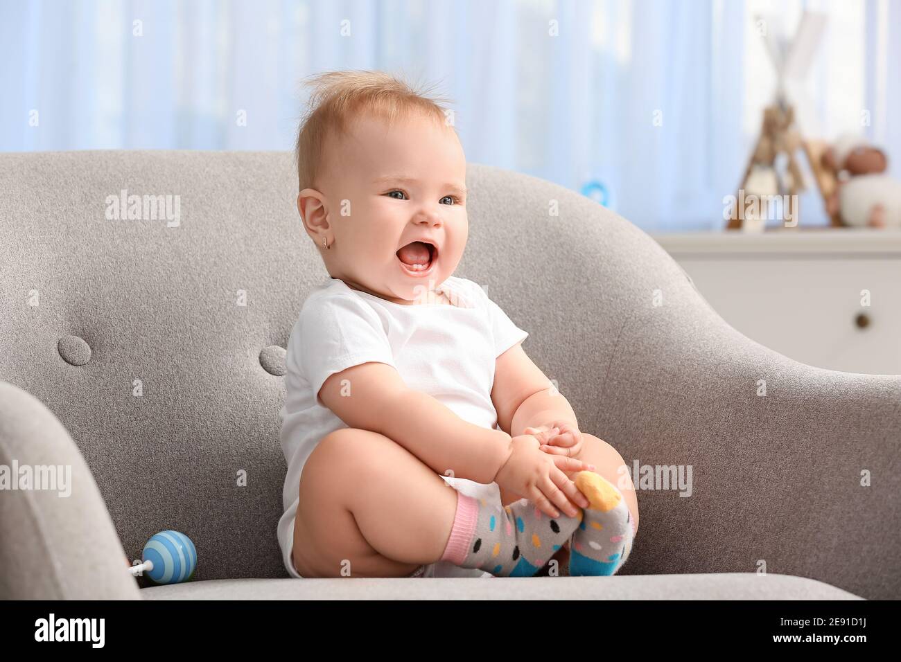Cute little baby sitting in armchair at home Stock Photo Alamy