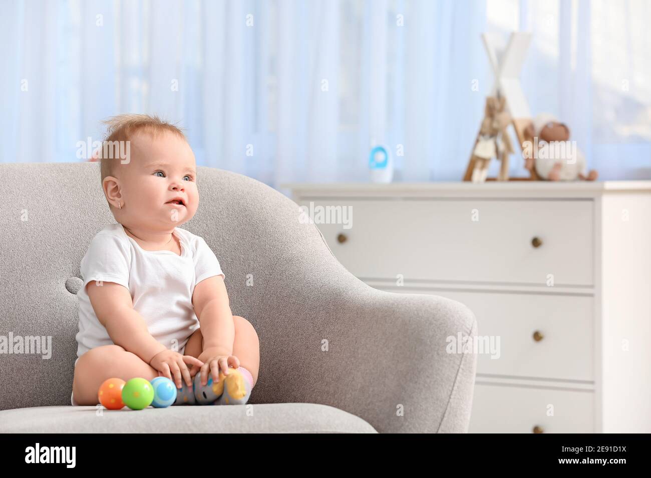 Cute little baby sitting in armchair at home Stock Photo Alamy