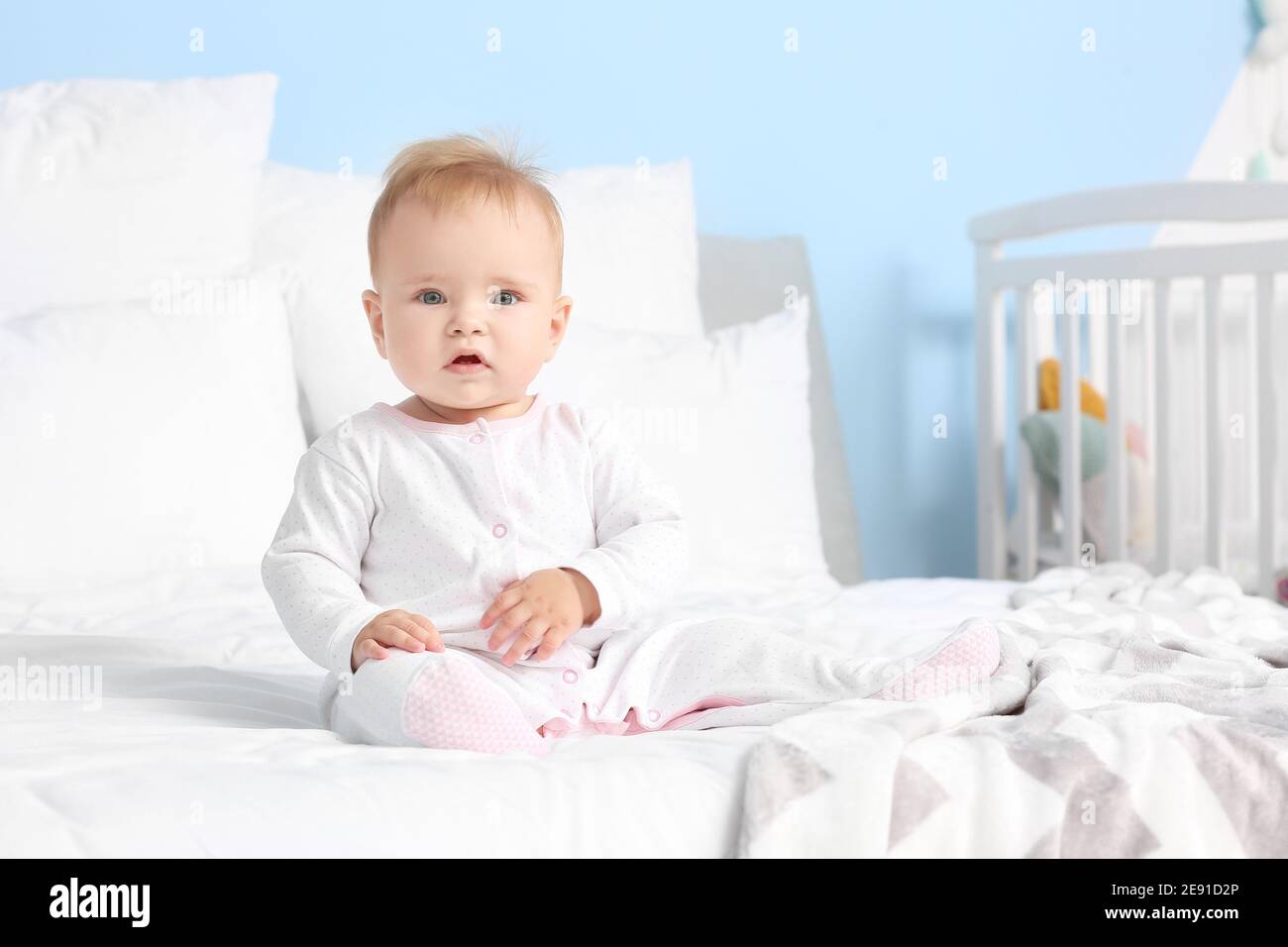 Cute little baby sitting on bed at home Stock Photo - Alamy
