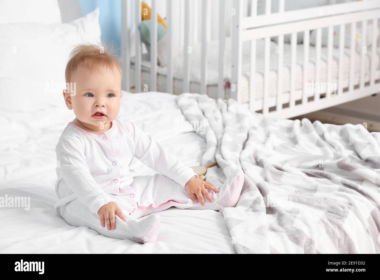 Cute little baby sitting on bed at home Stock Photo - Alamy