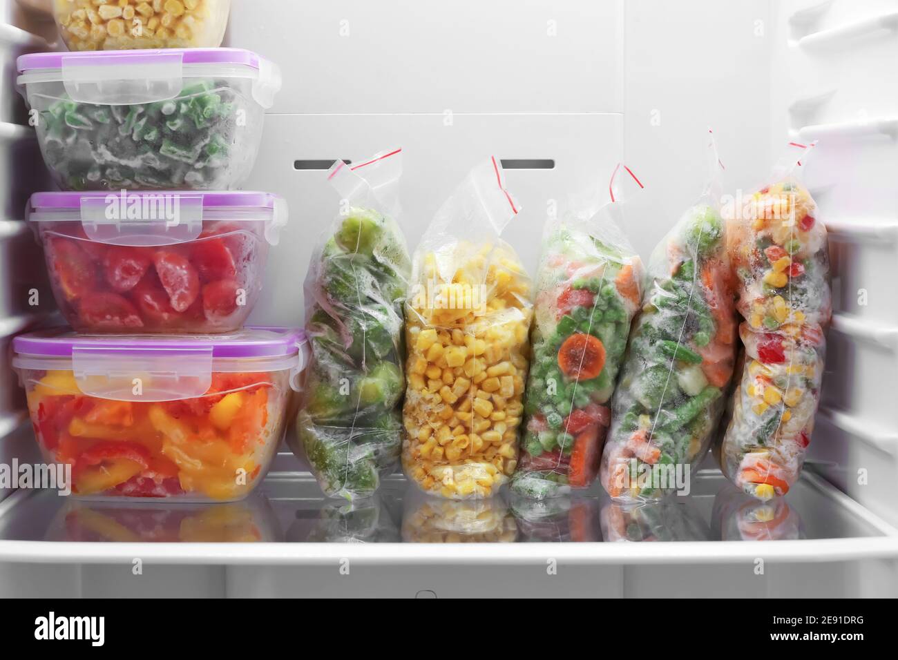 https://c8.alamy.com/comp/2E91DRG/containers-and-plastic-bags-with-frozen-vegetables-in-refrigerator-2E91DRG.jpg