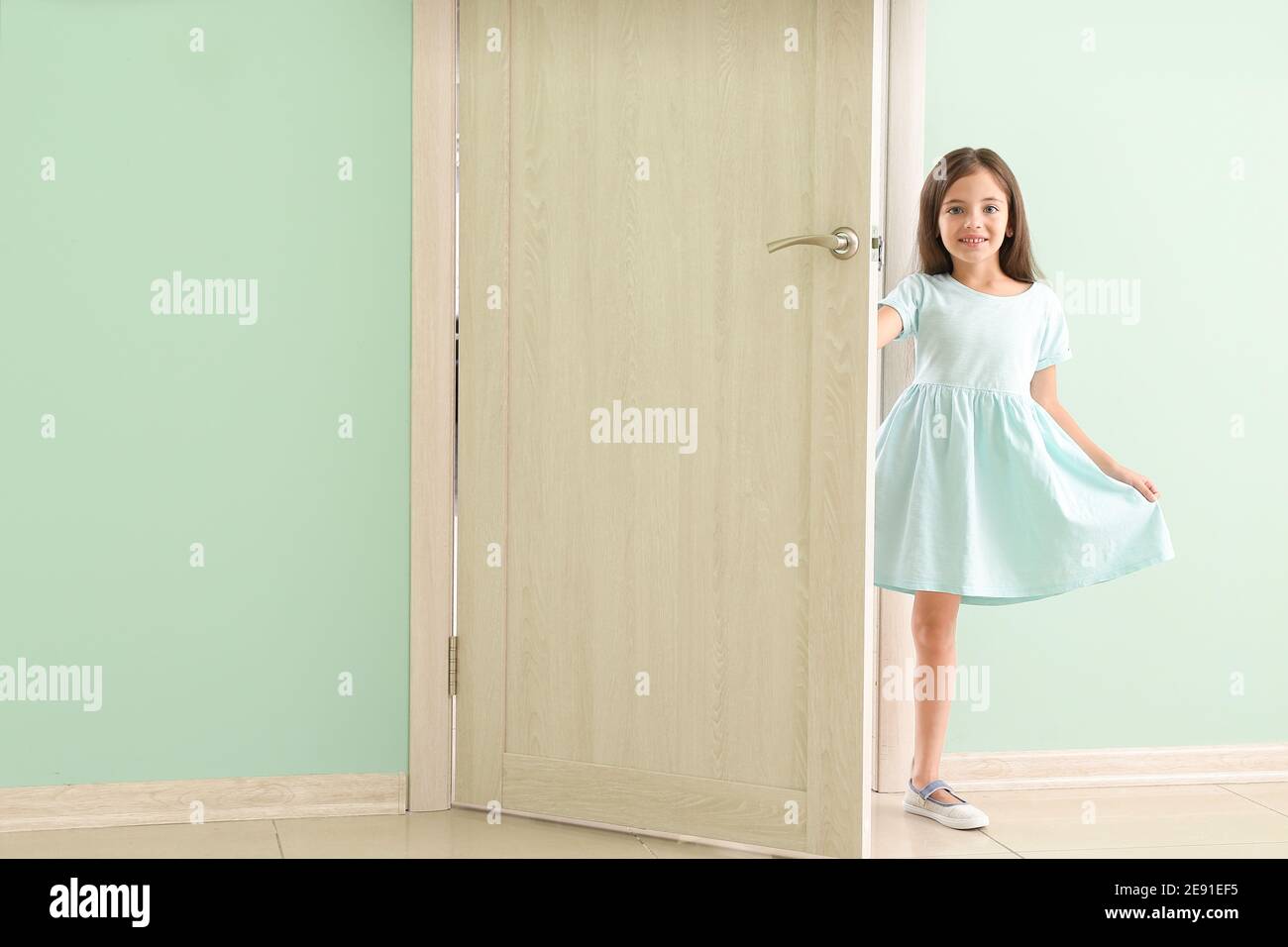 Cute little girl standing in doorway Stock Photo - Alamy