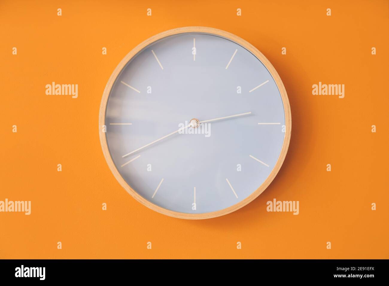 Modern clock hanging on color wall Stock Photo Alamy