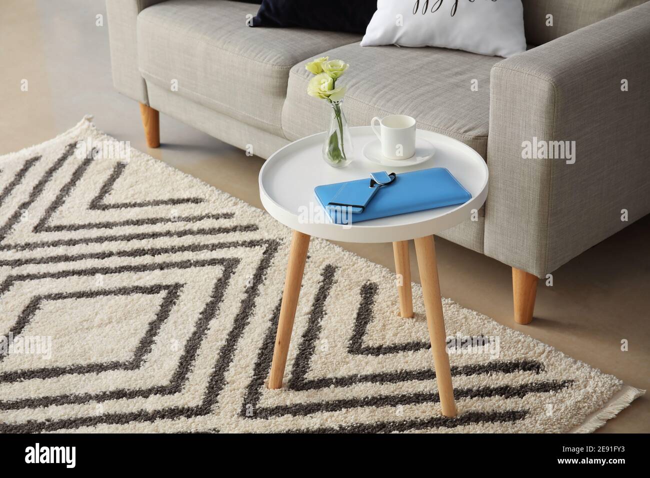 Stylish table and sofa in living room Stock Photo - Alamy