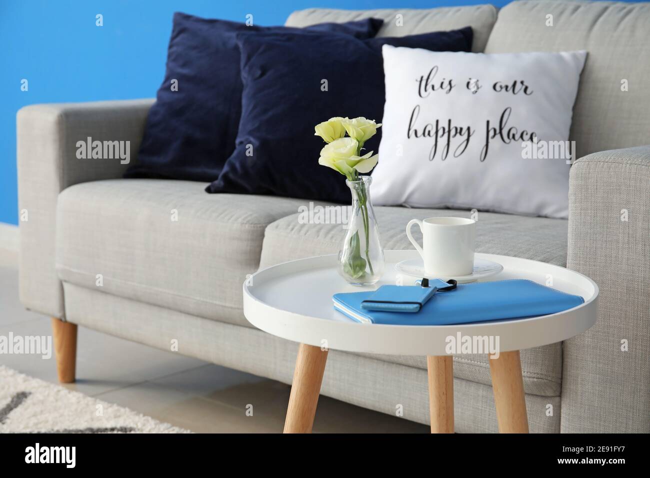 Stylish table and sofa in living room Stock Photo - Alamy