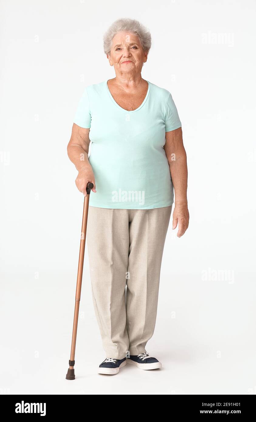 Senior woman with walking stick on white background Stock Photo Alamy