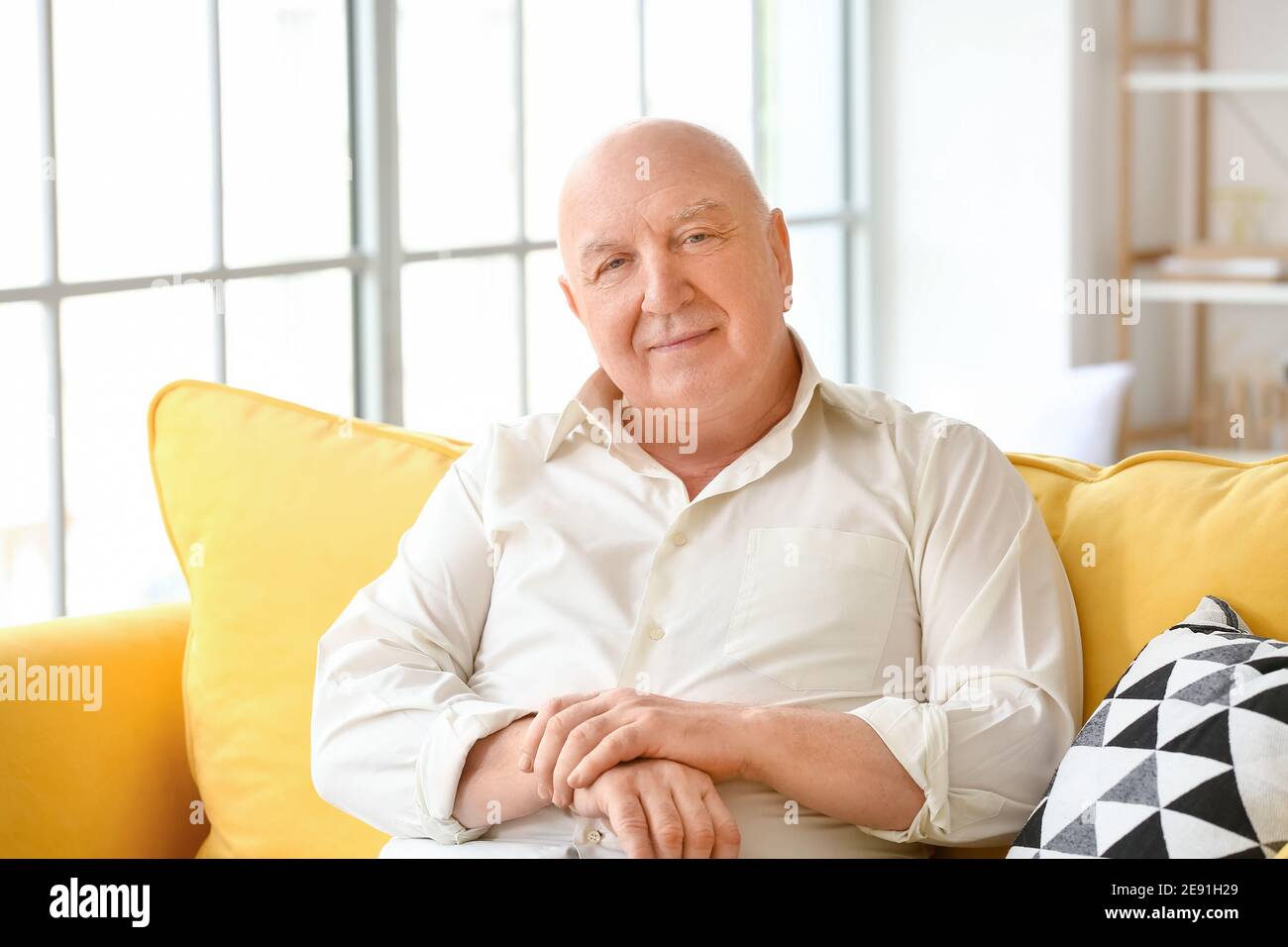 Senior man sitting on sofa at home Stock Photo - Alamy