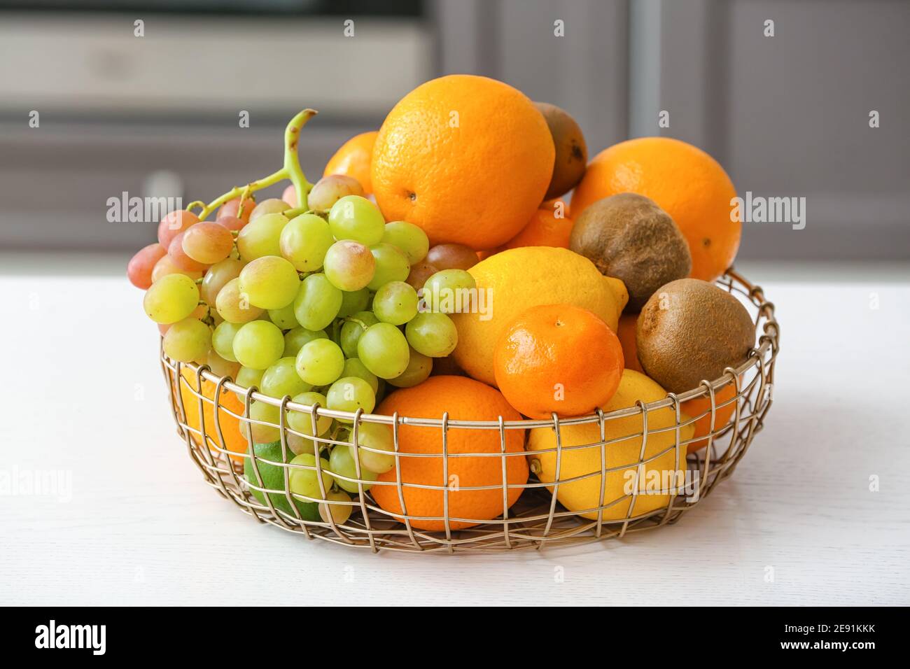 Basket with different fruits on kitchen table Stock Photo - Alamy