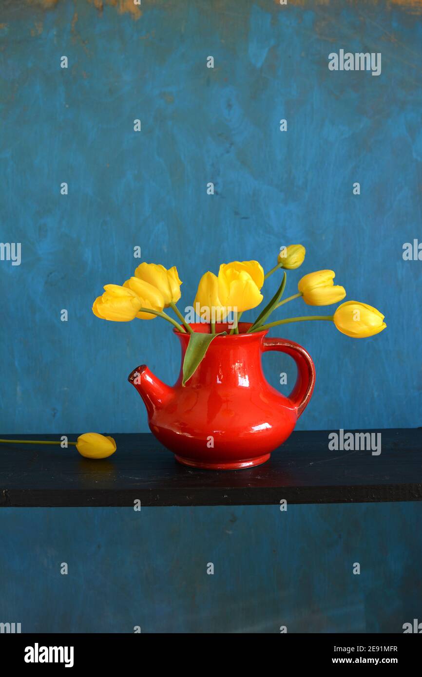 bouquet of yellow tulips in red vase Stock Photo