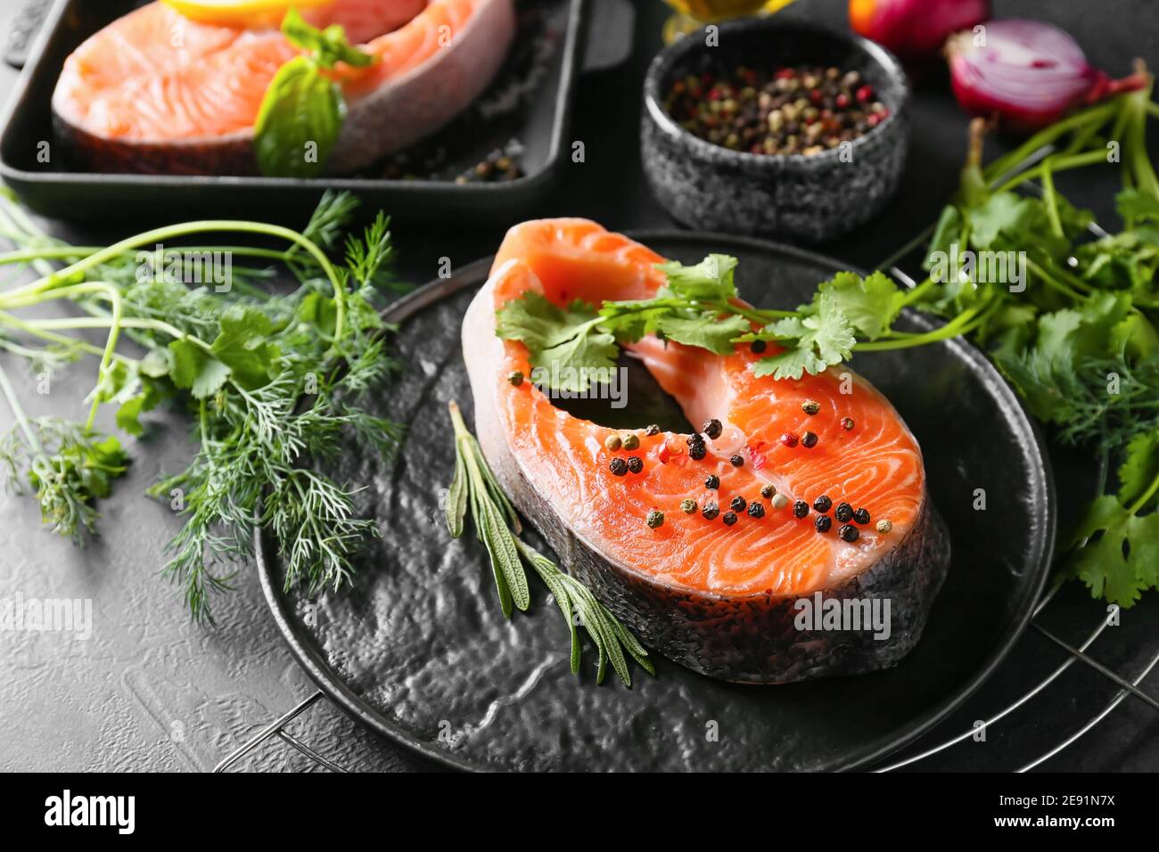 Plate with raw salmon steaks, herbs and spices on dark background Stock ...
