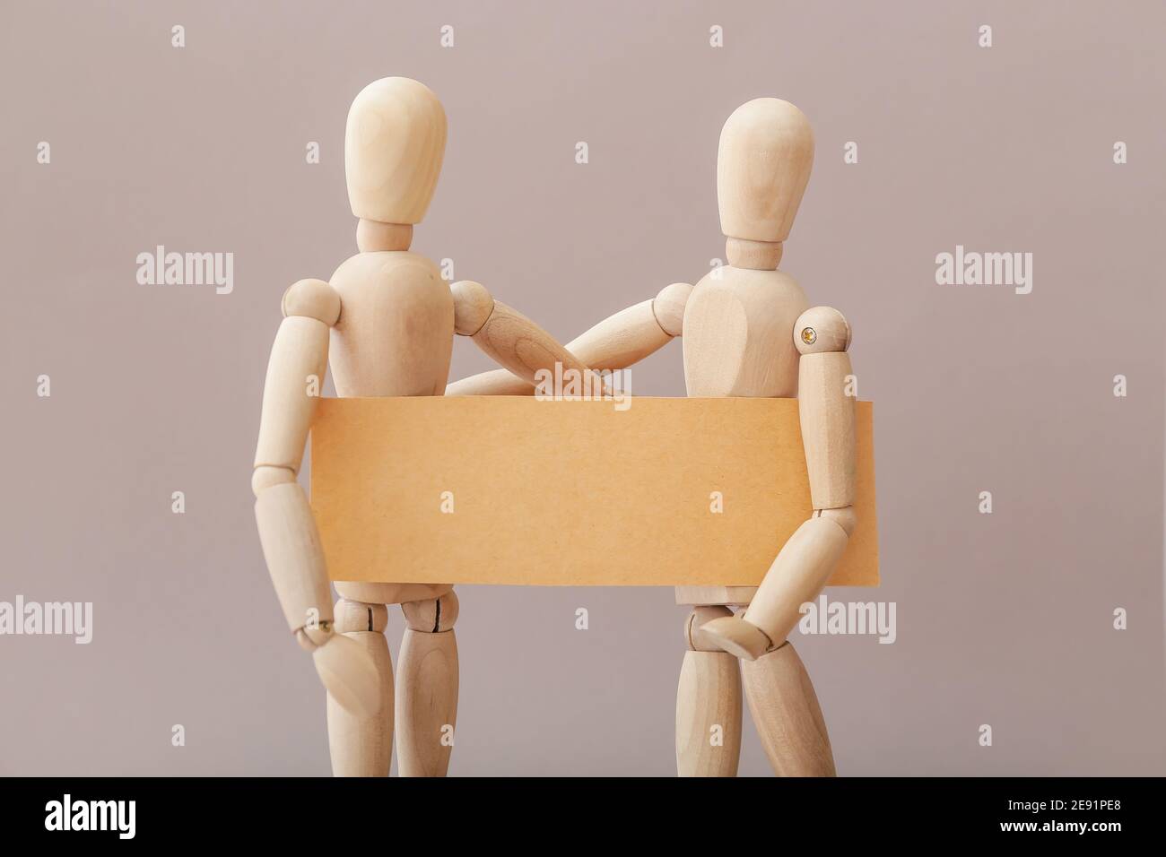 Wooden mannequins with blank poster on grey background Stock Photo - Alamy