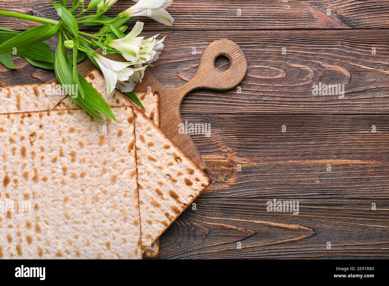 Jewish flatbread matza for Passover and flowers on wooden background Stock Photo Alamy