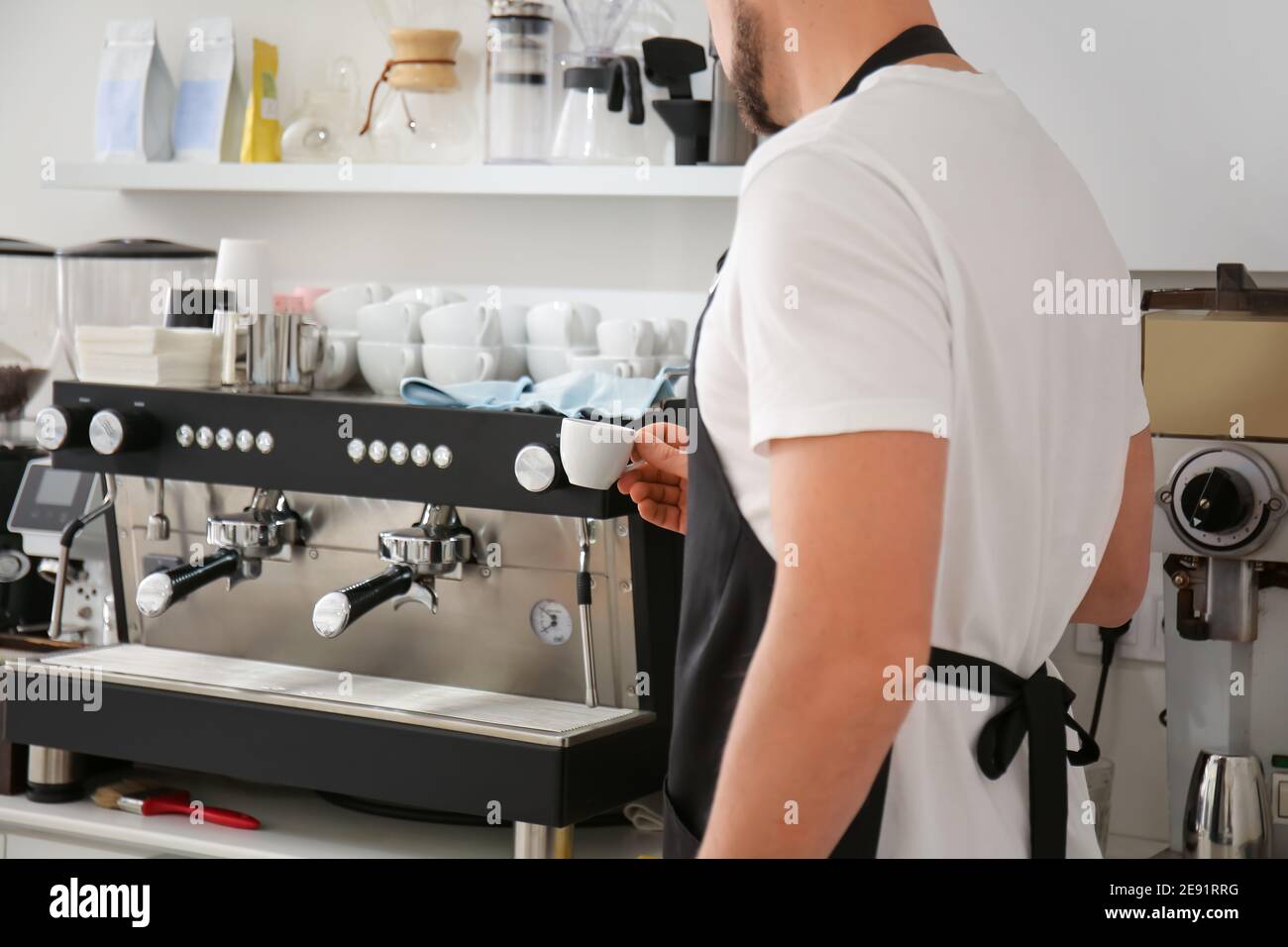 Barista making hot coffee in cafe Stock Photo