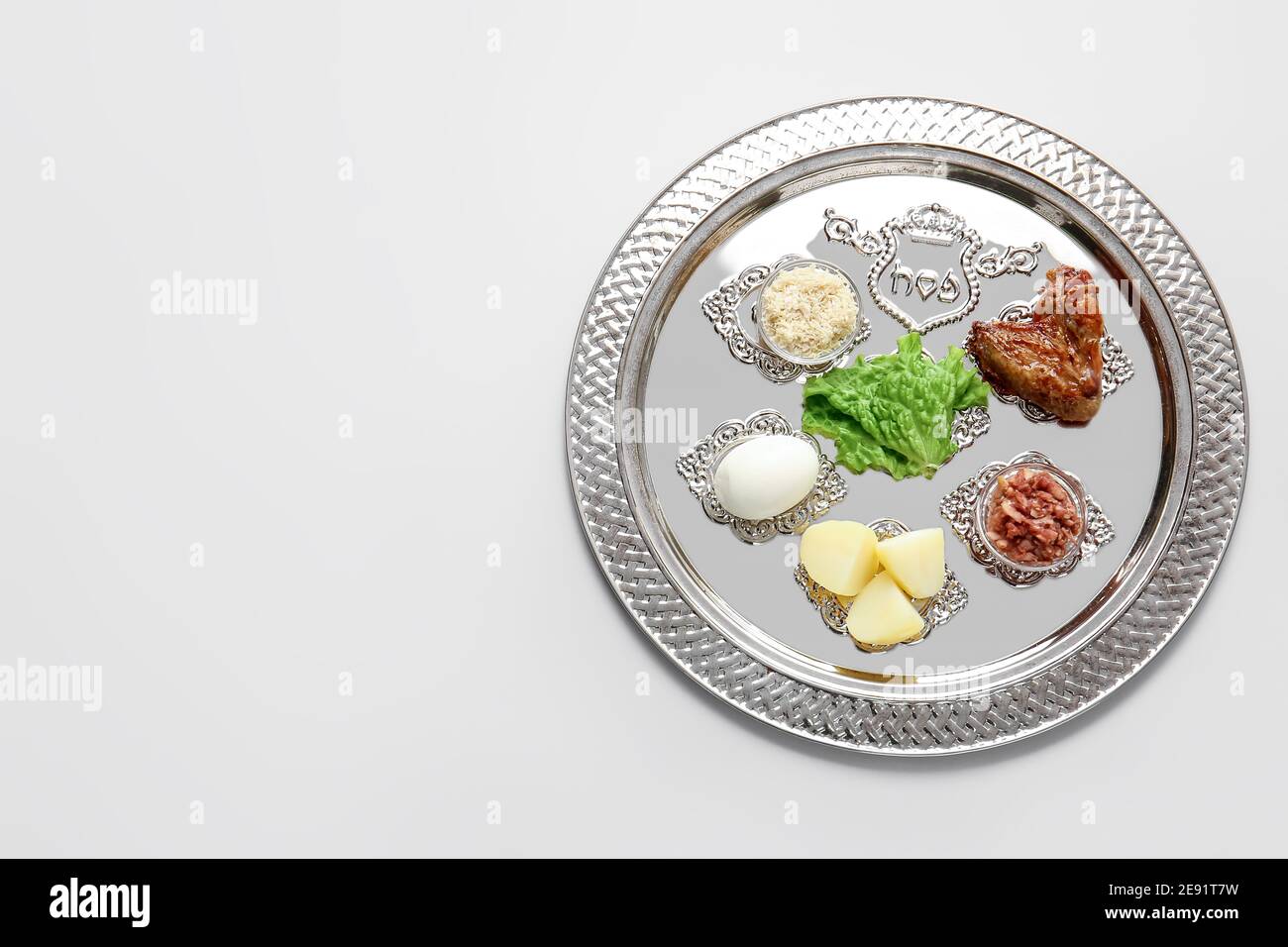 Passover Seder plate with traditional food on light background Stock ...