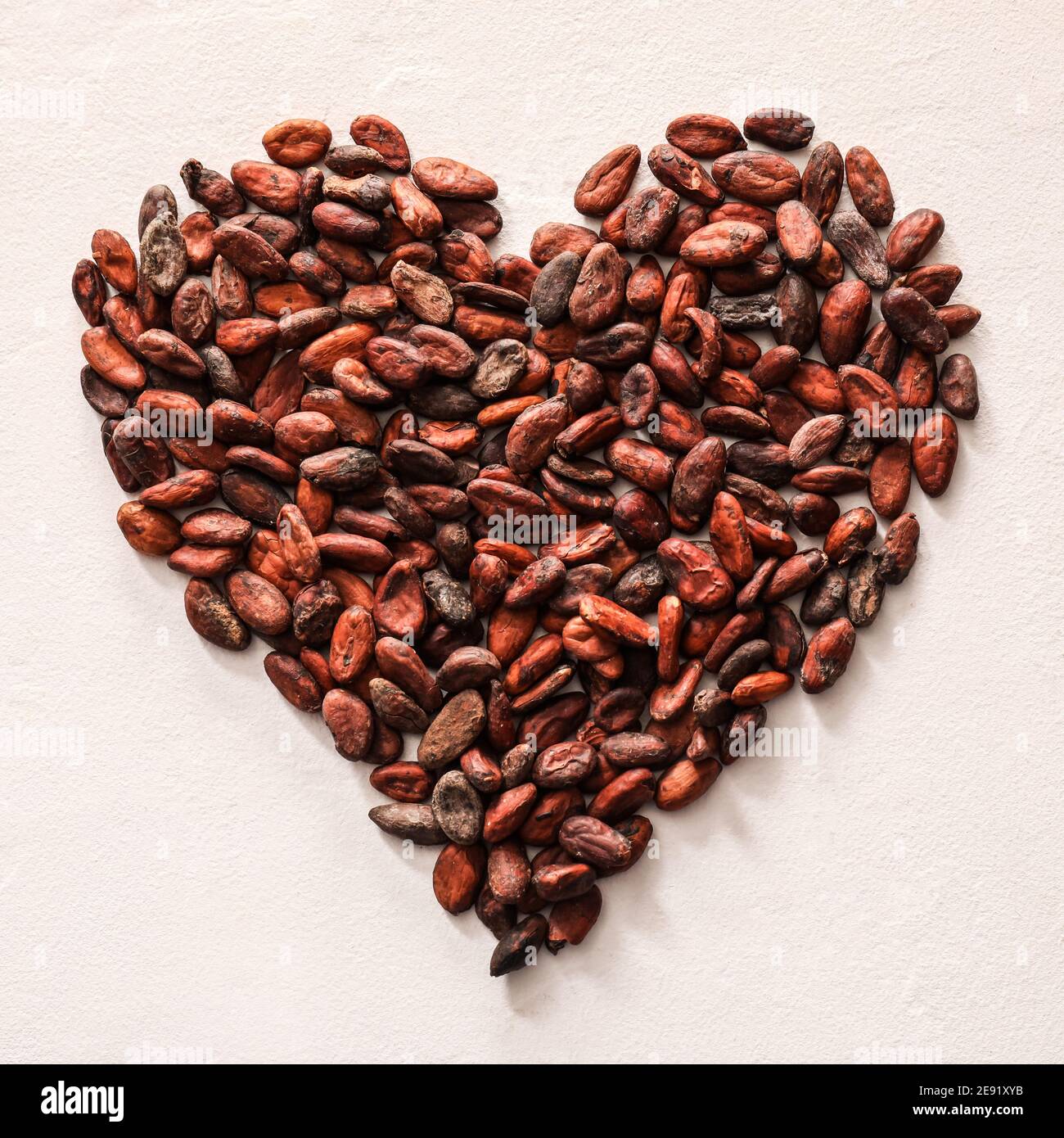 Heart made of cocoa beans on light background Stock Photo Alamy