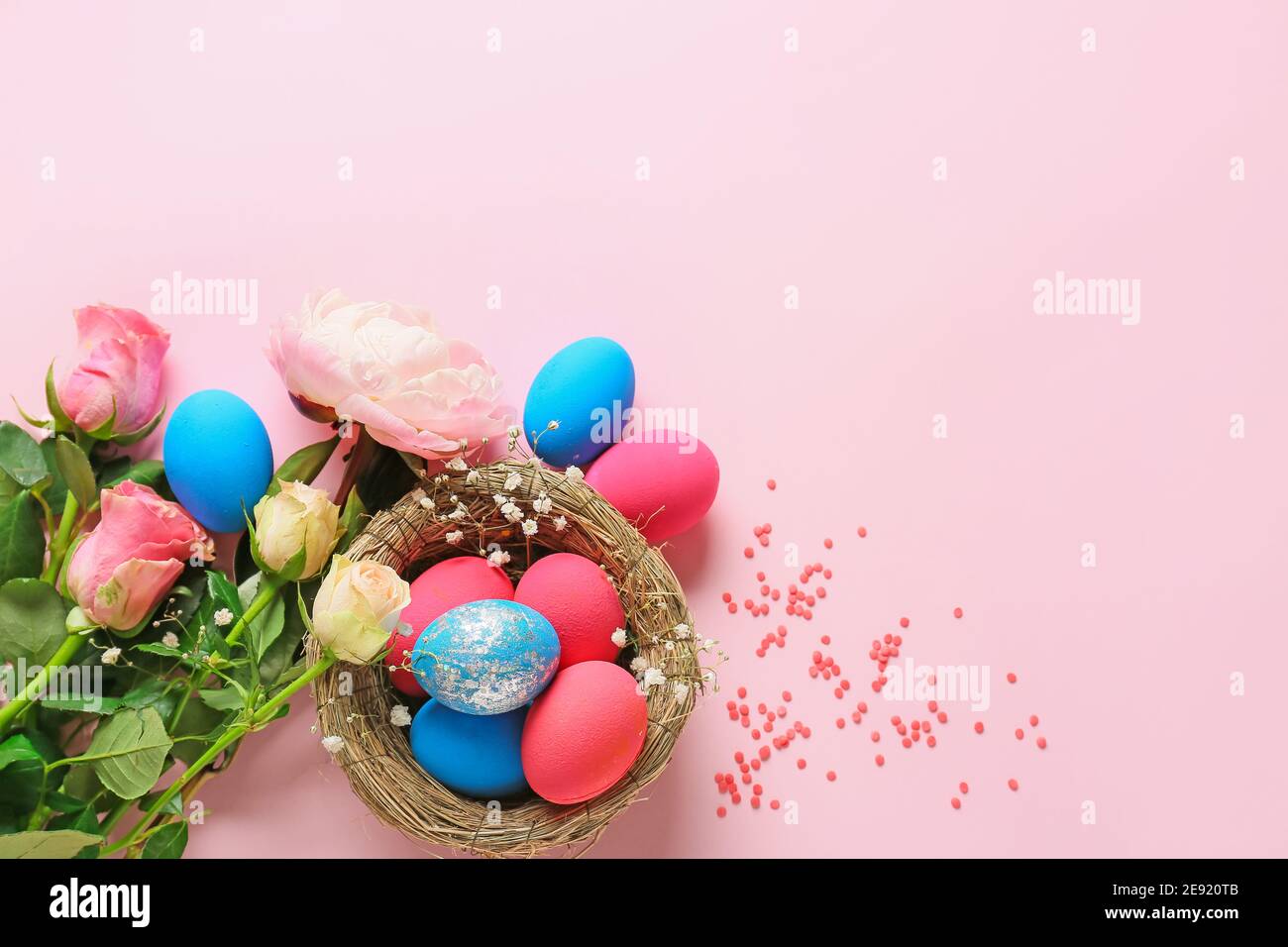 Composition with beautiful Easter eggs and flowers on color background ...