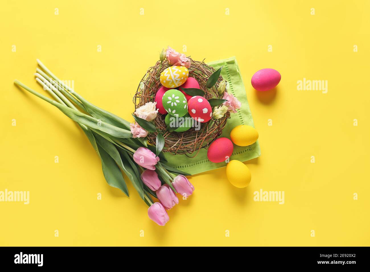 Composition with beautiful Easter eggs and flowers on color background ...