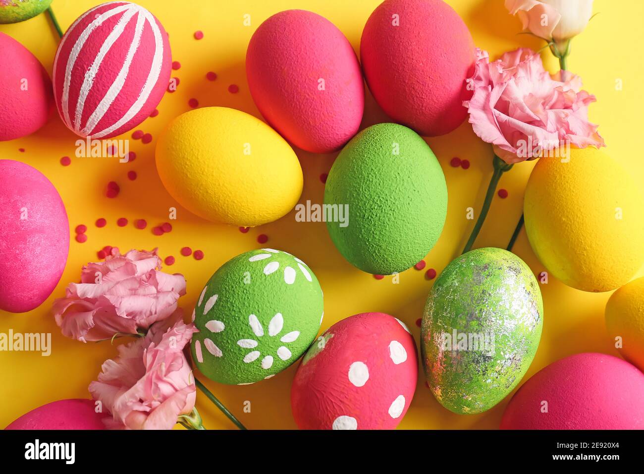 Composition with beautiful Easter eggs and flowers on color background ...