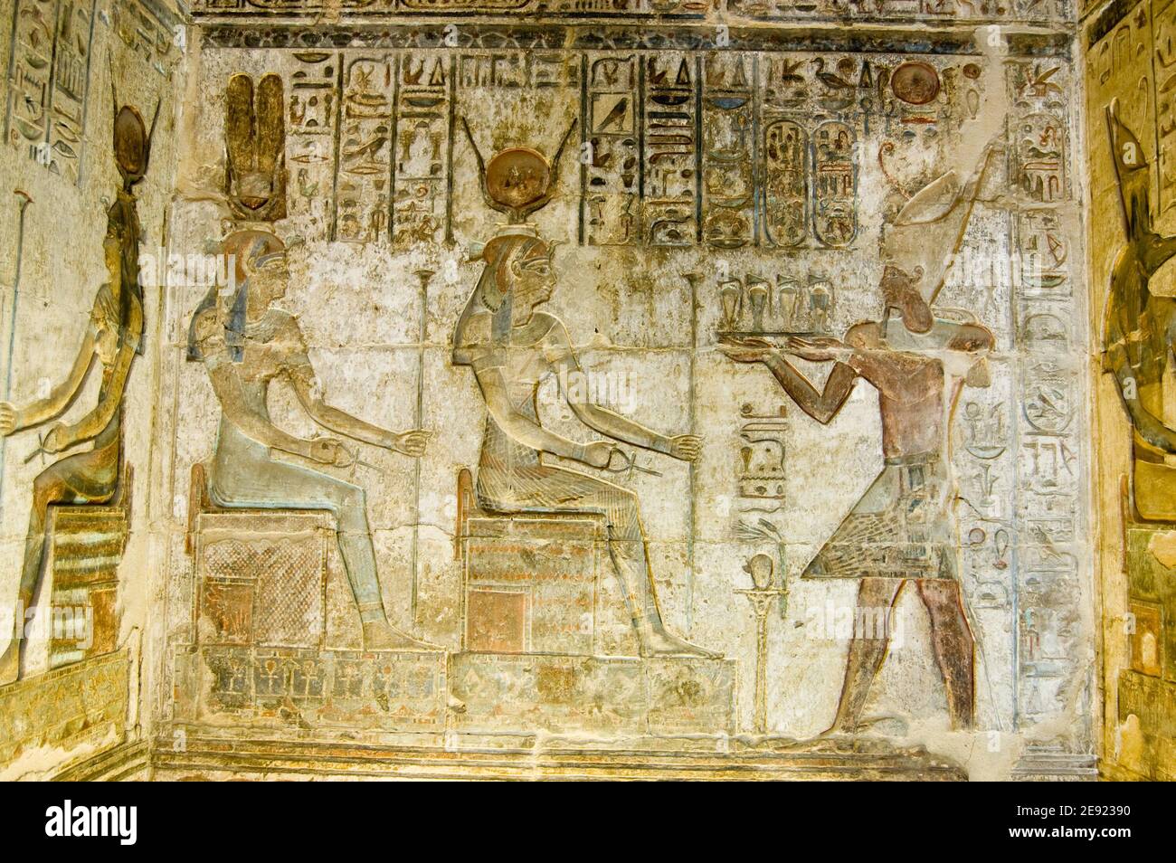 Ancient Egyptian coloured bas relief showing the Pharaoh Ptolemy IV making an offering to the goddesses Hathor and Maat. Temple at Deir el Medina, ove Stock Photo