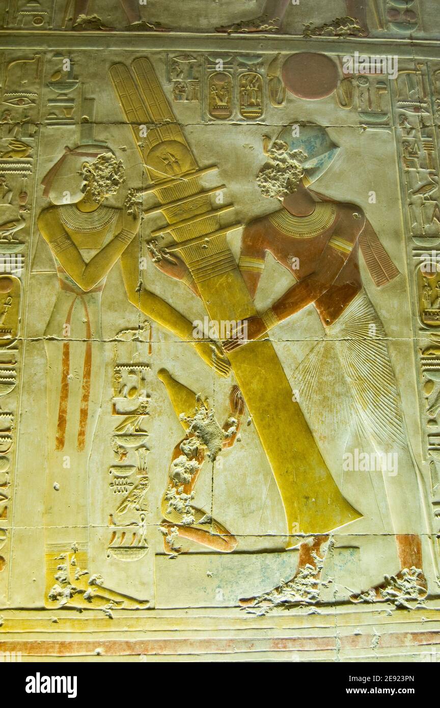 Ancient bas relief showing the Pharaoh Seti I raising the Djed column with the goddess Isis. Osiris Hall. Temple of Abydos, el Balyana, Egypt. Ancient Stock Photo