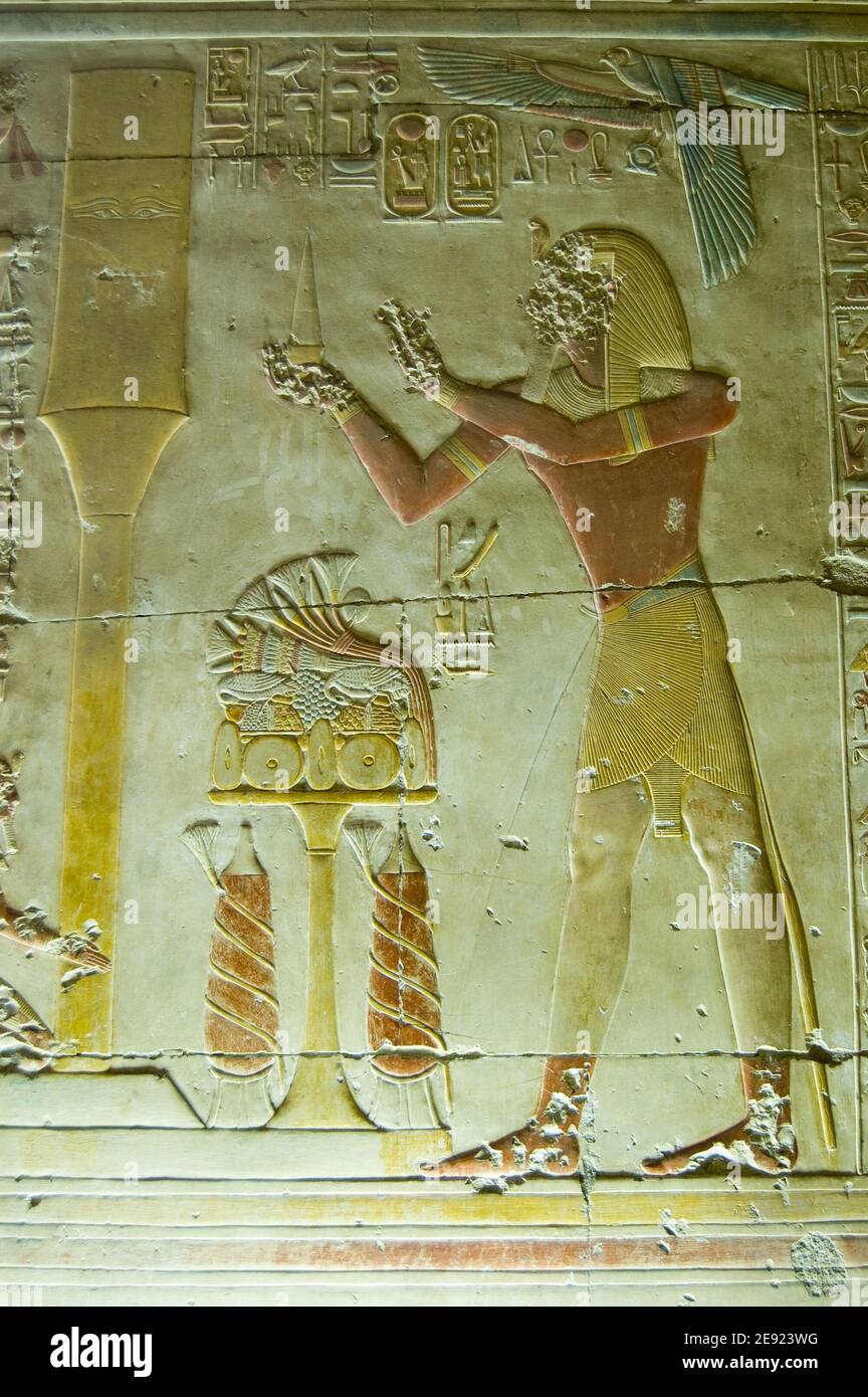 Ancient Egyptian bas relief carving showing the Pharaoh Seti I making an offering to the sacred Djed column. Interior of Abydos Temple, el Balyana, Eg Stock Photo