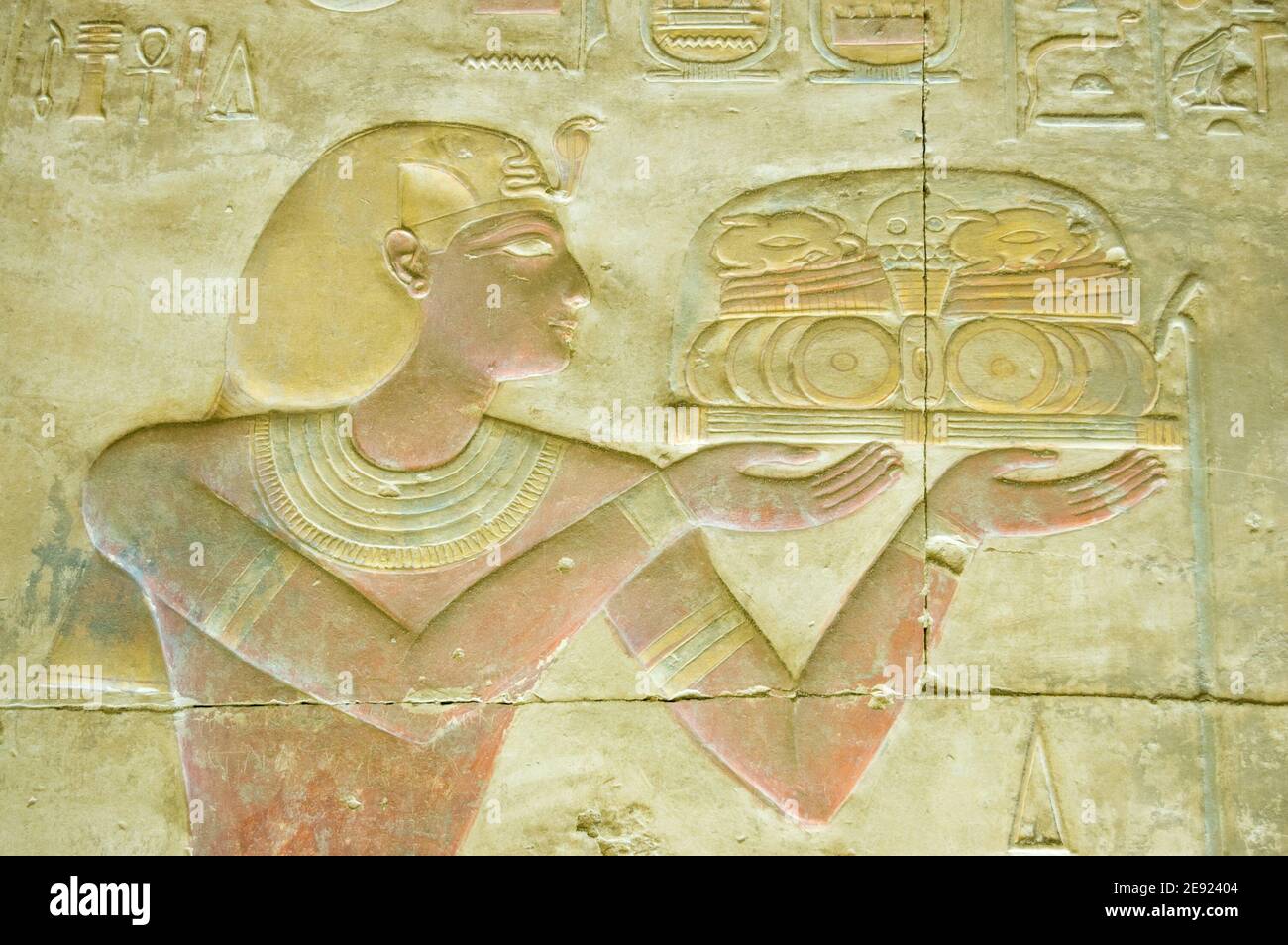 Ancient Egyptian bas relief sculpture showing the Pharaoh Seti I with an offering for the gods. Temple of Osiris, Abydos near el Balyana, Egypt. Ancie Stock Photo