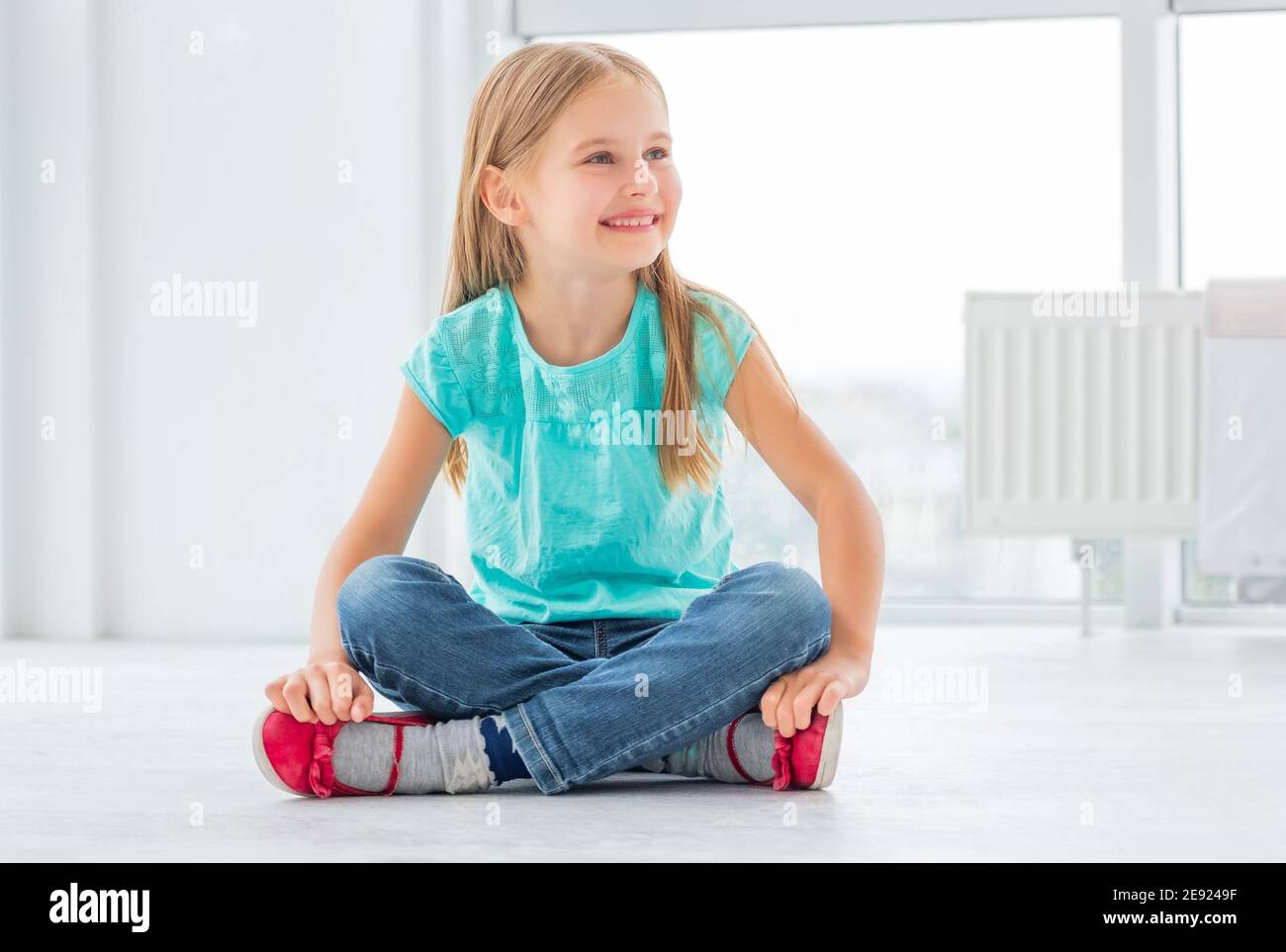 Smiling blonde girl sitting crossed hi-res stock photography and images ...