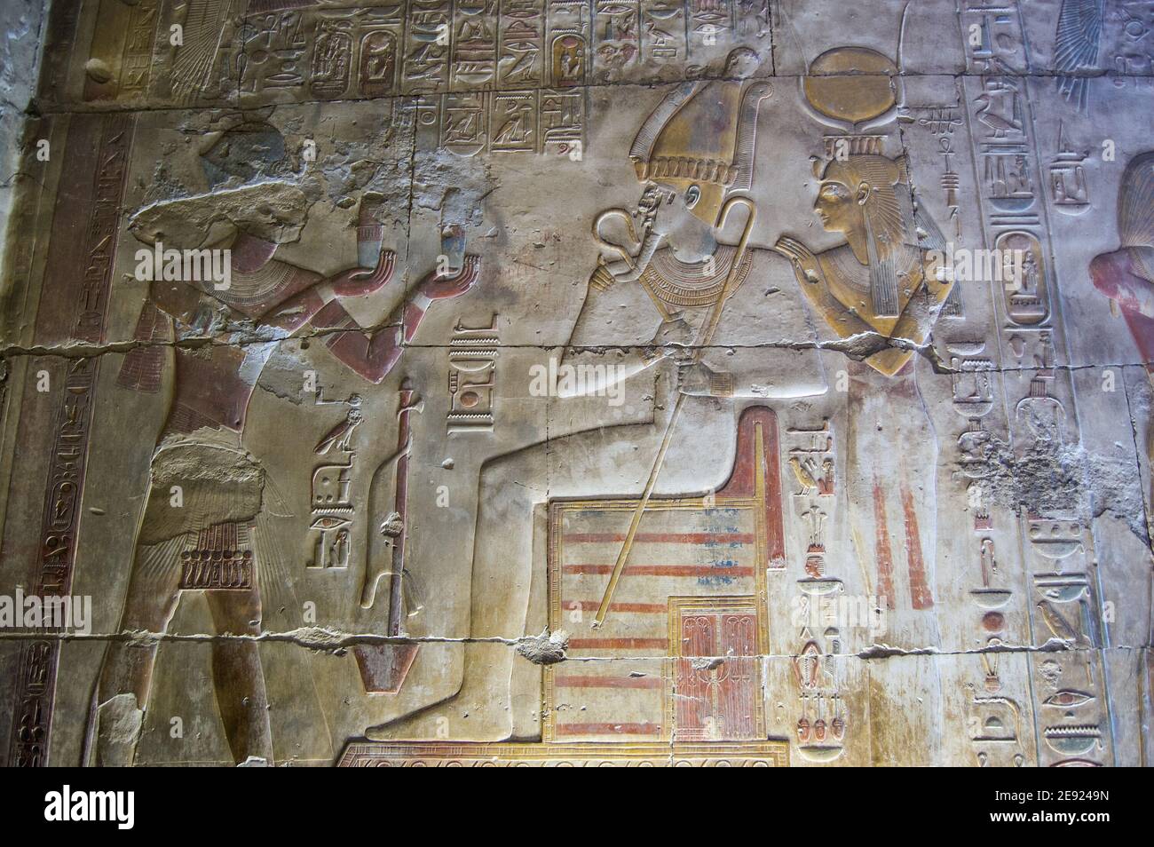 Heiroglyphic wall carving at Abydos Temple showing the Ancient Egyptian Pharaoh Seti I making an offering to the gods Osiris and Hathor. Stock Photo