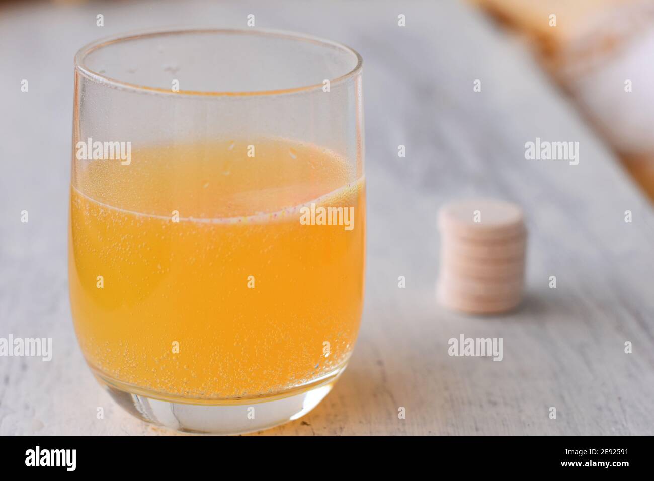 Vitamins, minerals and supplement concept/ Effervescent tablet on white background and orange effervescent bubbles of calcium and vitamin C Stock Photo