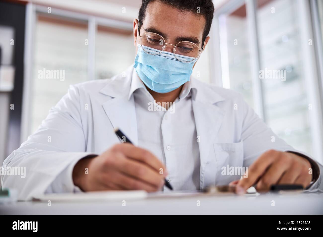 Focused eye doctor working in his office Stock Photo